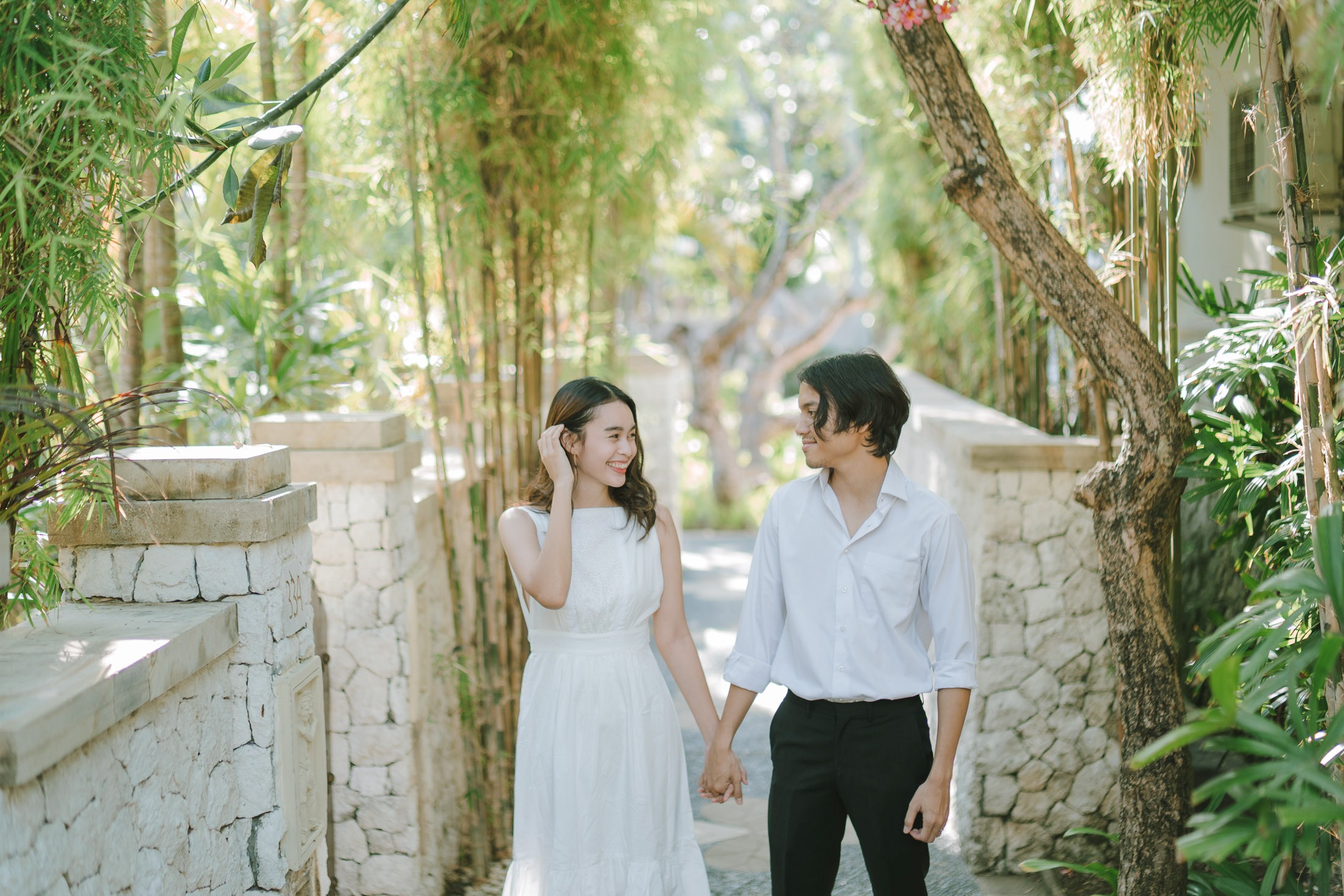 Intimate couple walking through the garden during a photography session at Novotel Bali Benoa in Tanjung Benoa Bali.