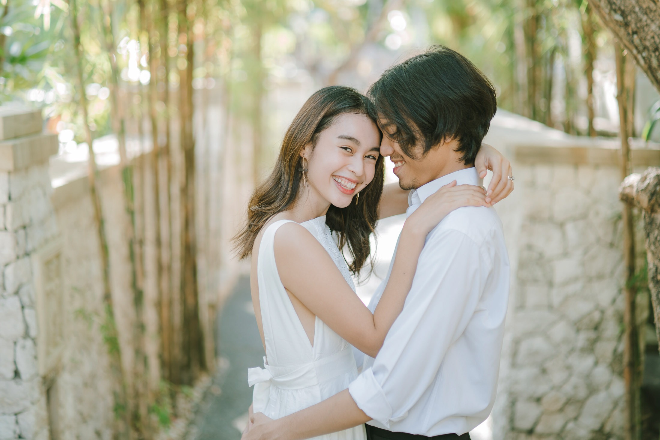 Intimate couple embrace in the garden during a photography session at Novotel Bali Benoa in Tanjung Benoa Bali.