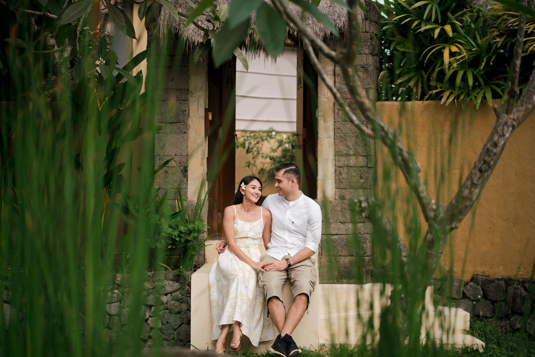 Romantic couple seated together in tropical garden at Waka Gangga West Bali