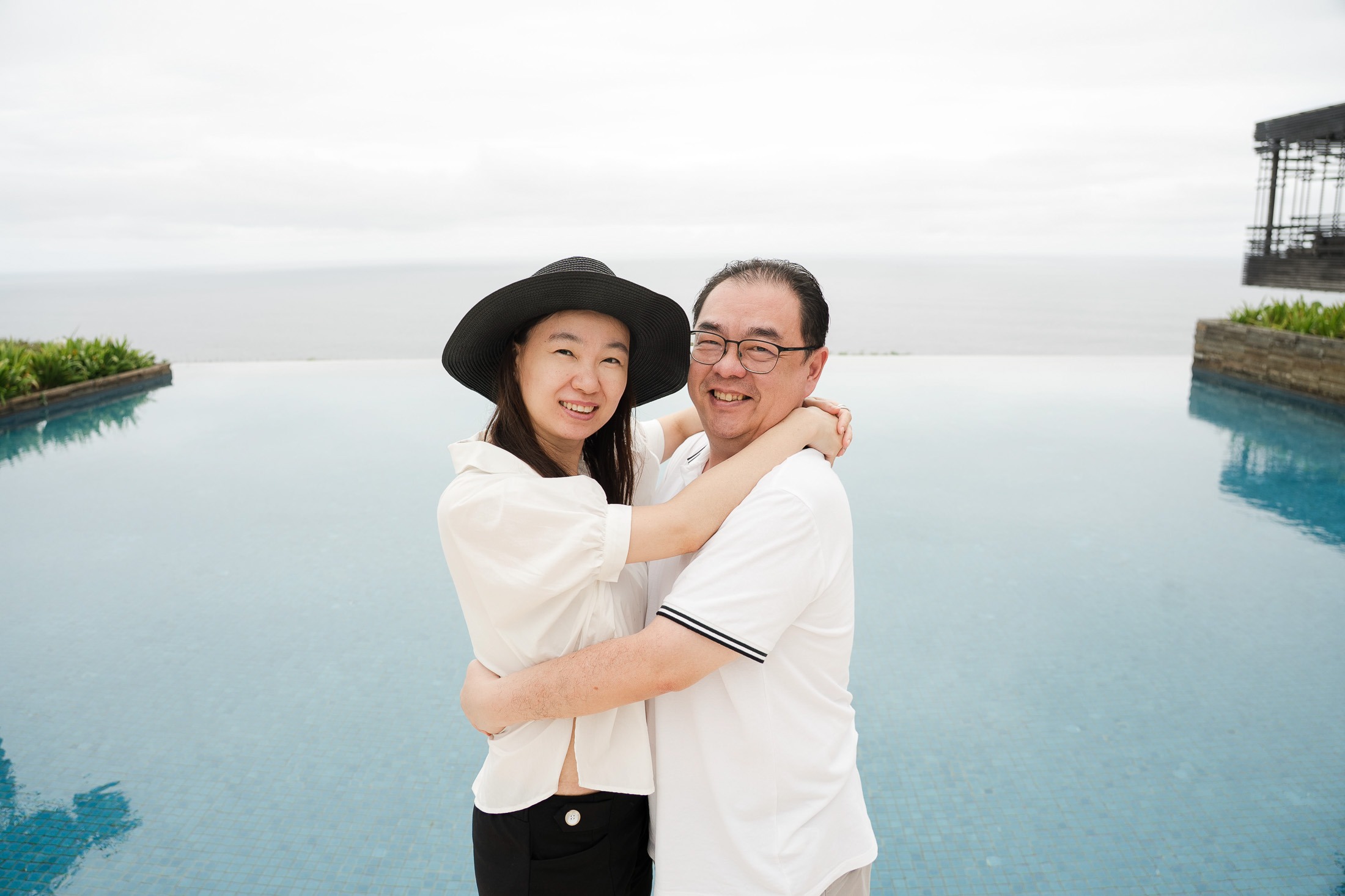 Couple embracing near infinity pool at Alila Villas Uluwatu Bali with ocean view background