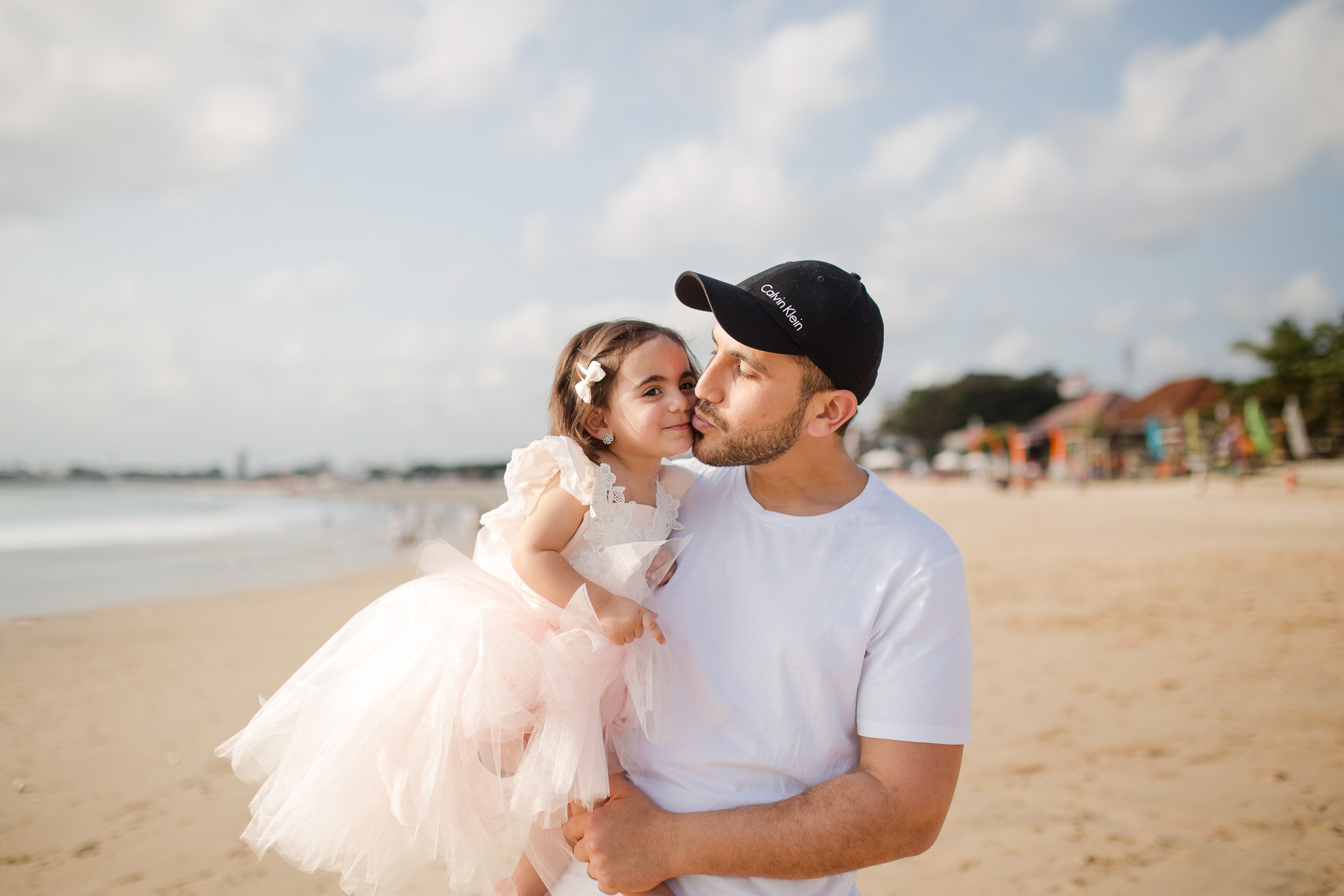 family photography Jimbaran Beach Bali father and daughter walking along shoreline