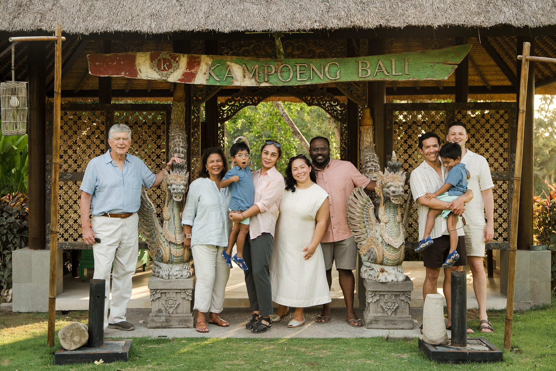  family standing in front of traditional balinese pavilion at rimba by ayana bali during a luxury family photography session