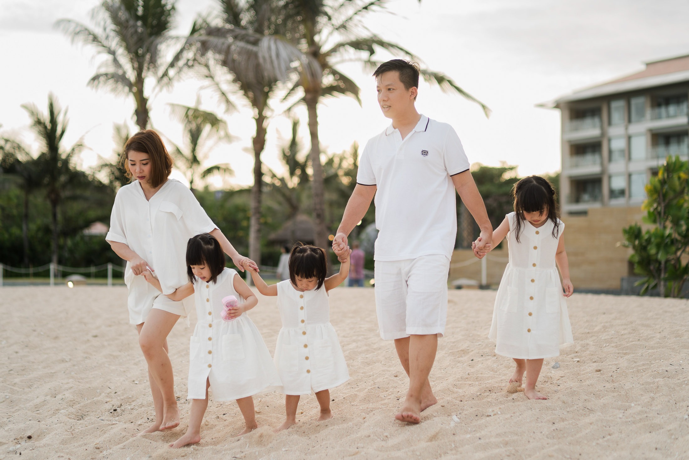 Family walking together along the beach at The Mulia Nusa Dua Bali during a relaxed family photography session