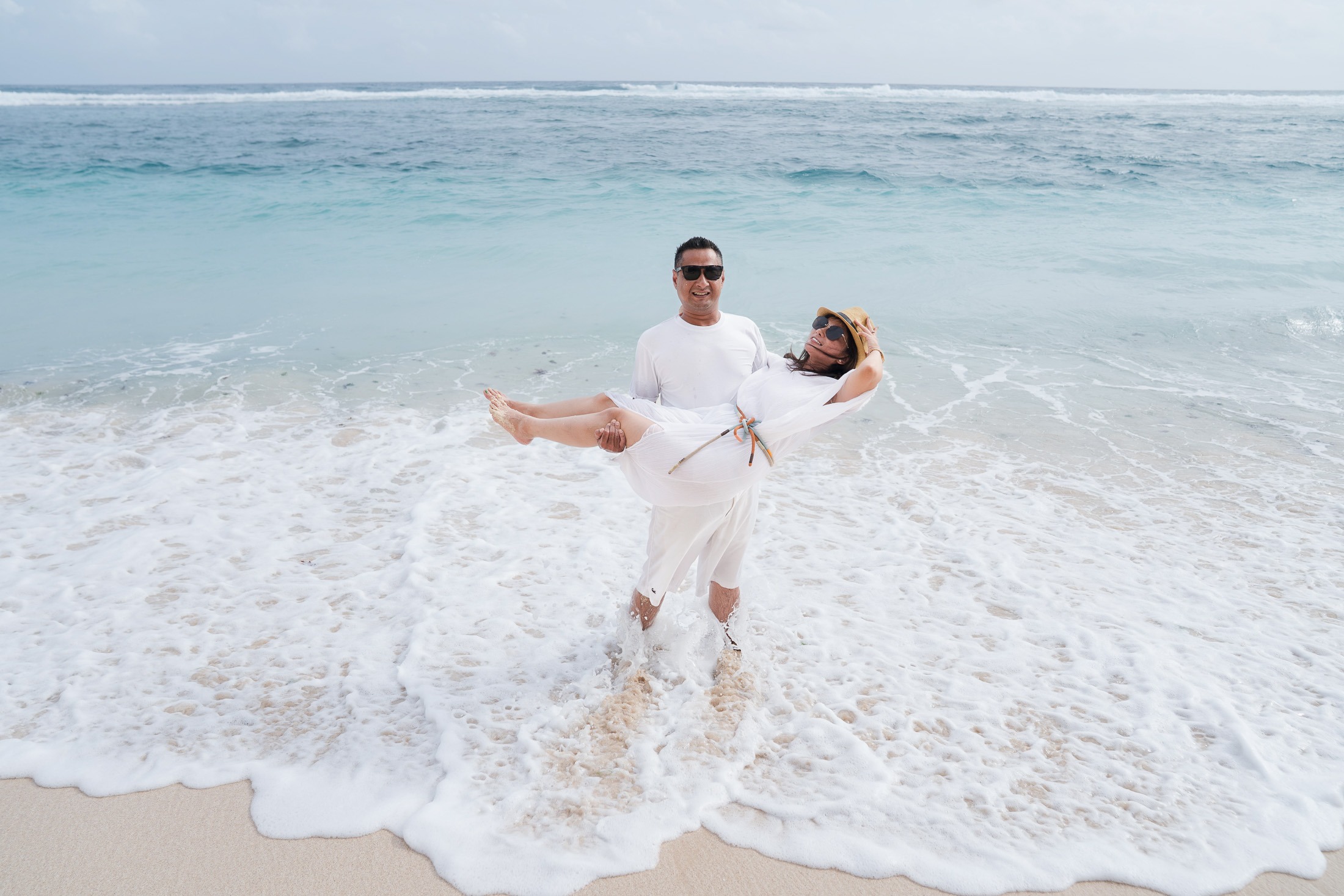 Family playing in the waves during a beach photography session at Karma Kandara Bali  