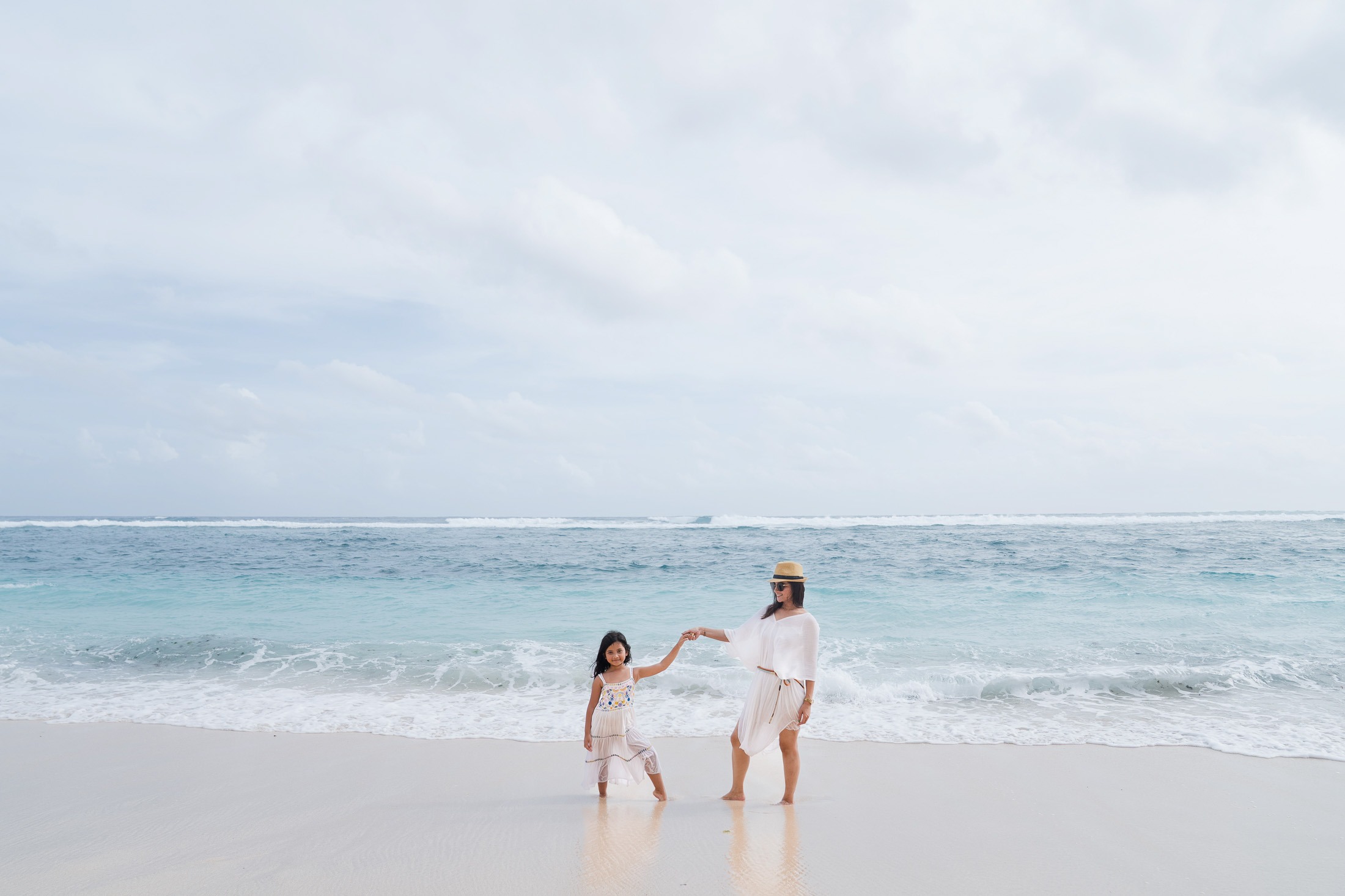 Family walking together by the ocean at Karma Kandara Bali in a wide scenic view  