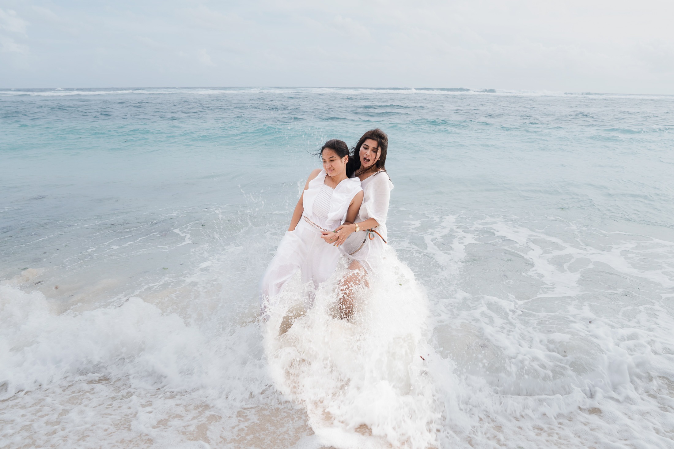 Family playing together in the ocean at Karma Kandara beach Bali  