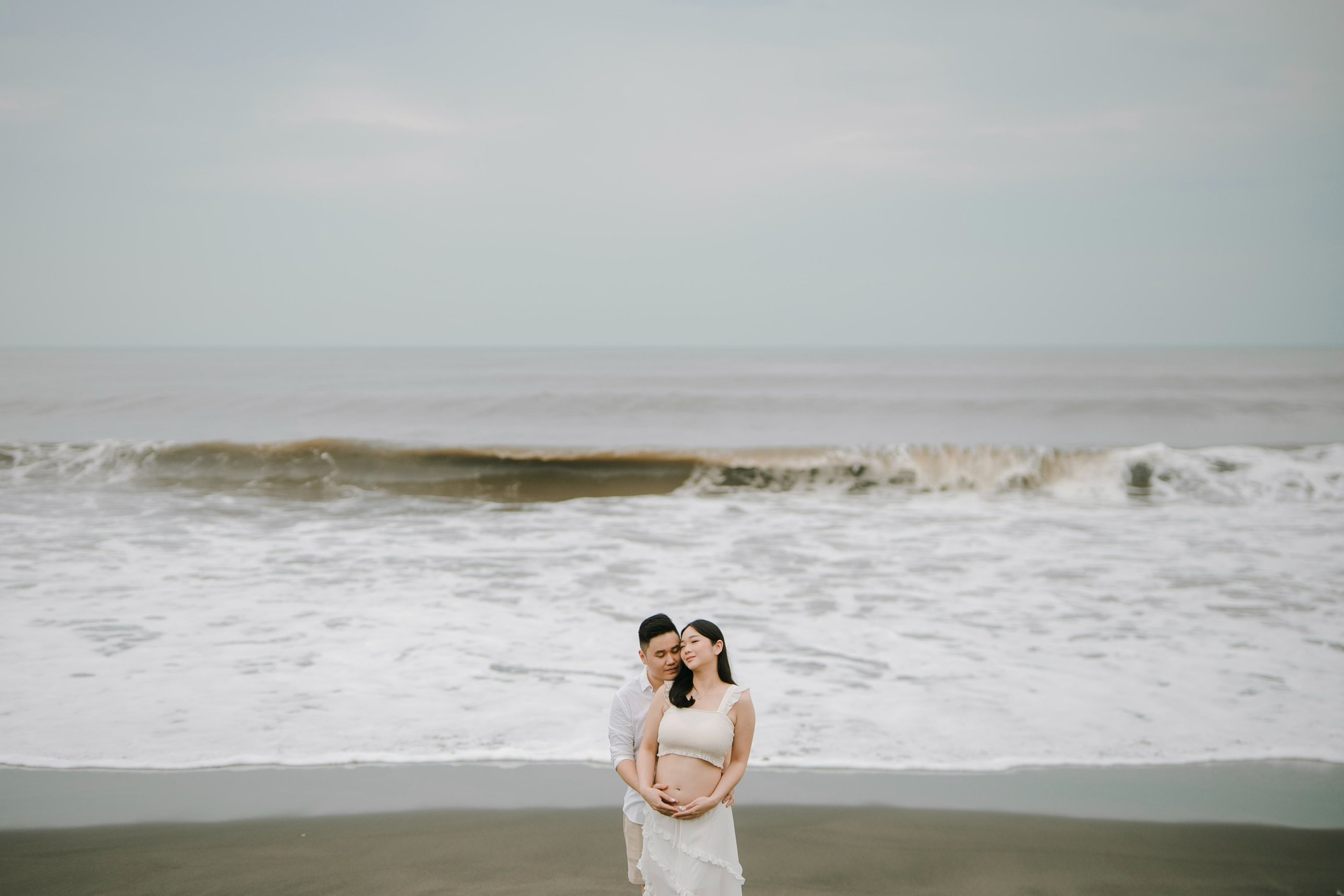 intimate couple session on Bali beach with ocean waves at sunset