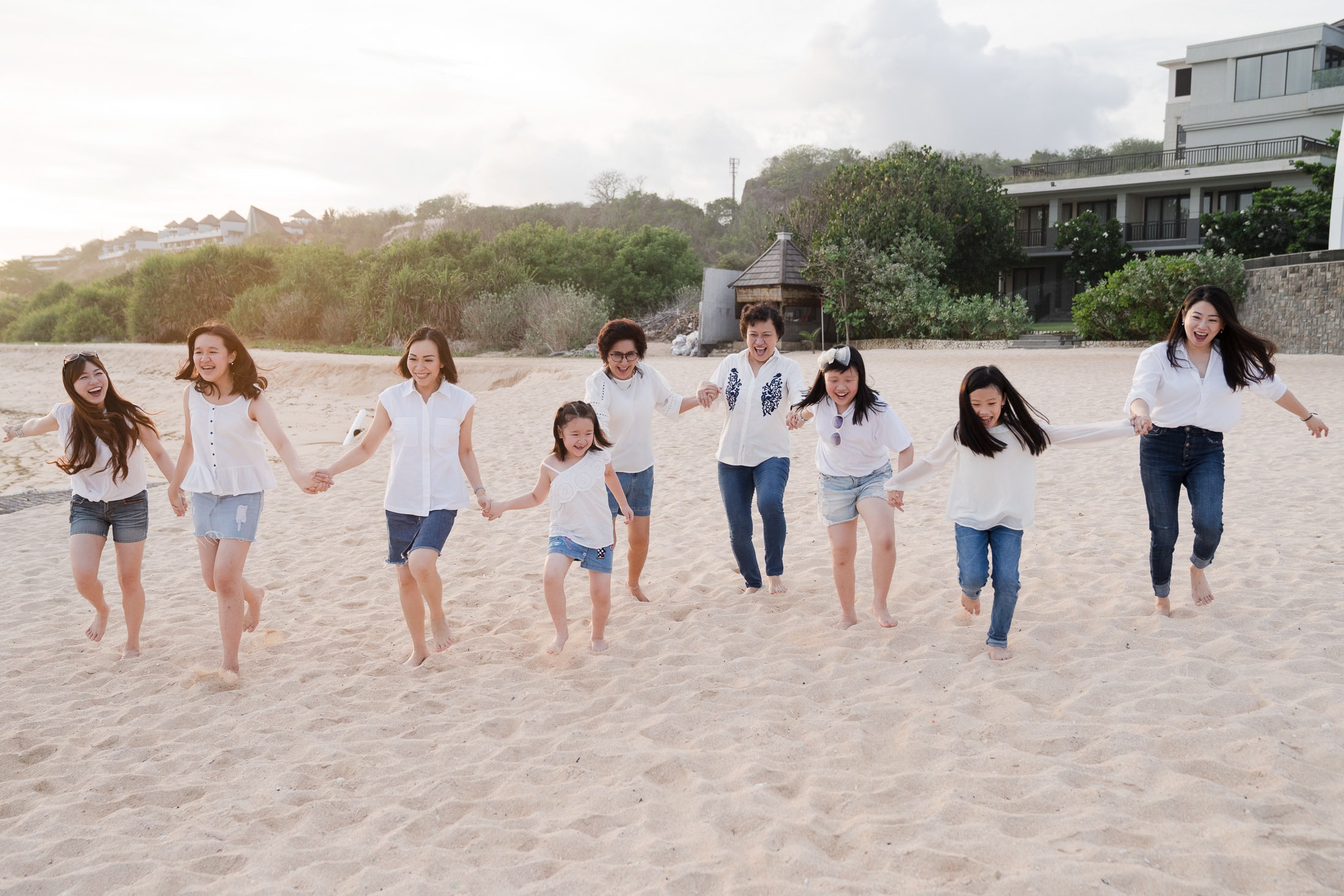 Extended family portrait standing together on the beach at The Ritz-Carlton Bali Nusa Dua