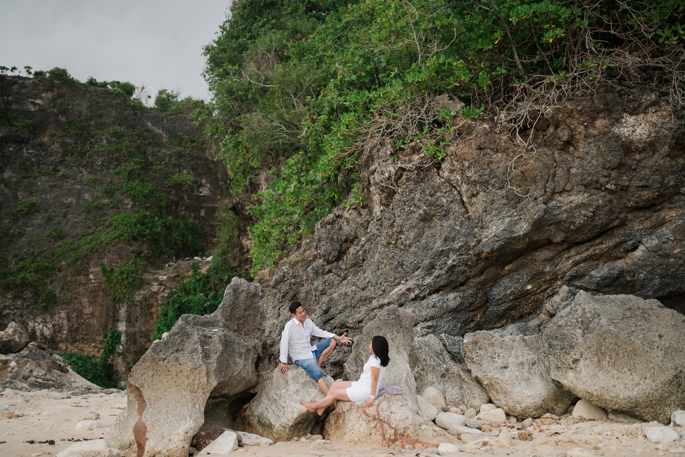 Family sitting near the limestone cliffs of Melasti Beach Bali captured during a lifestyle family photography session