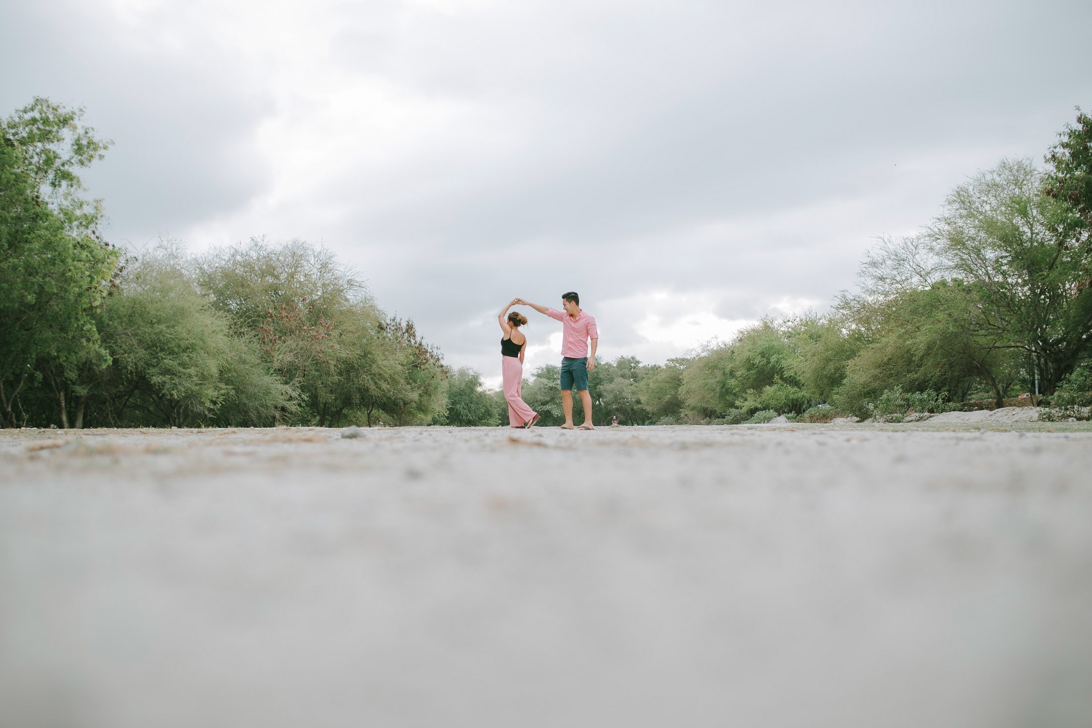 Wide beach scene of intimate couple during sunset session in Serangan Benoa Bali.