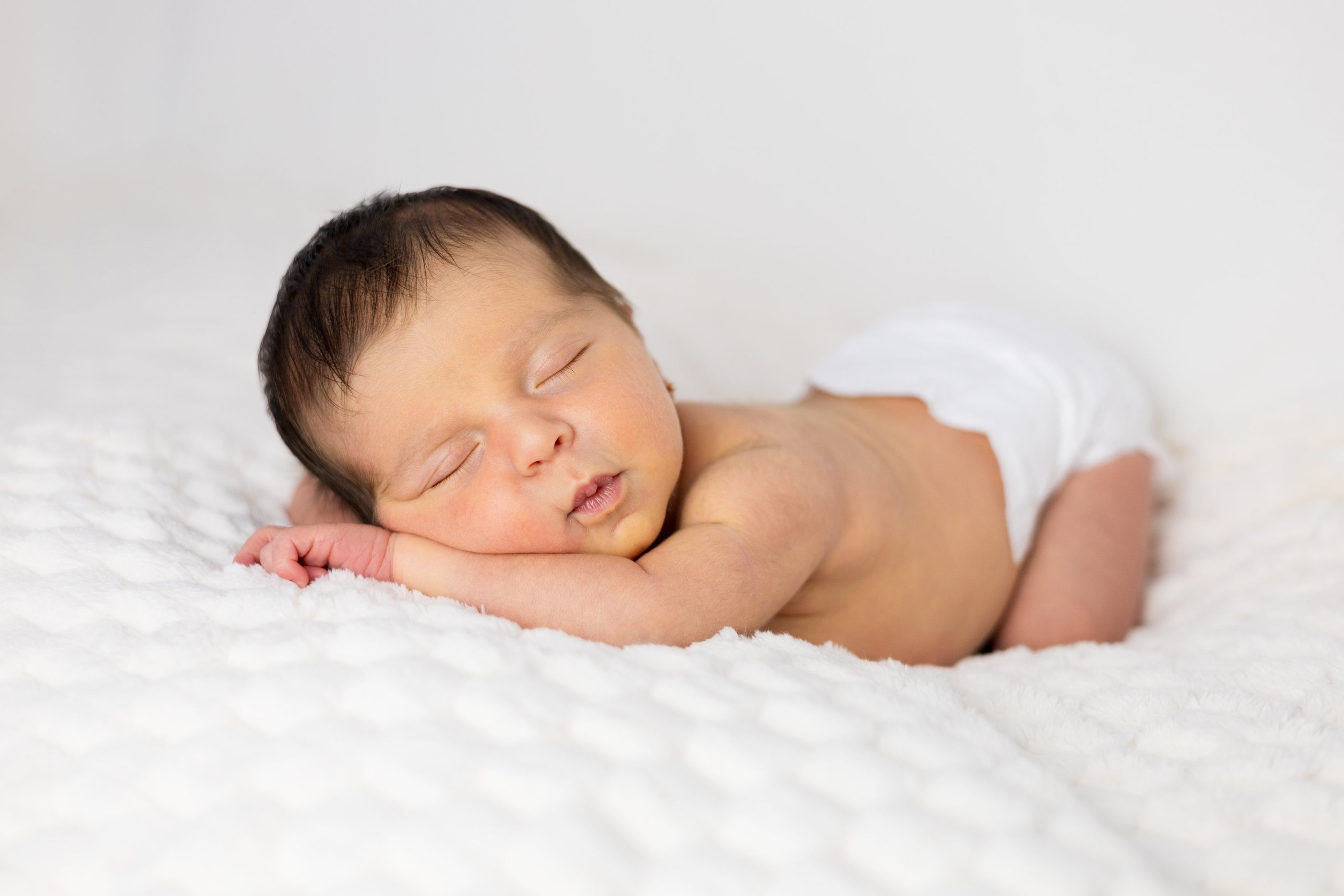 Sessió de fotos newborn a Girona amb una bebè recent nascuda dormint en estudi fotogràfic