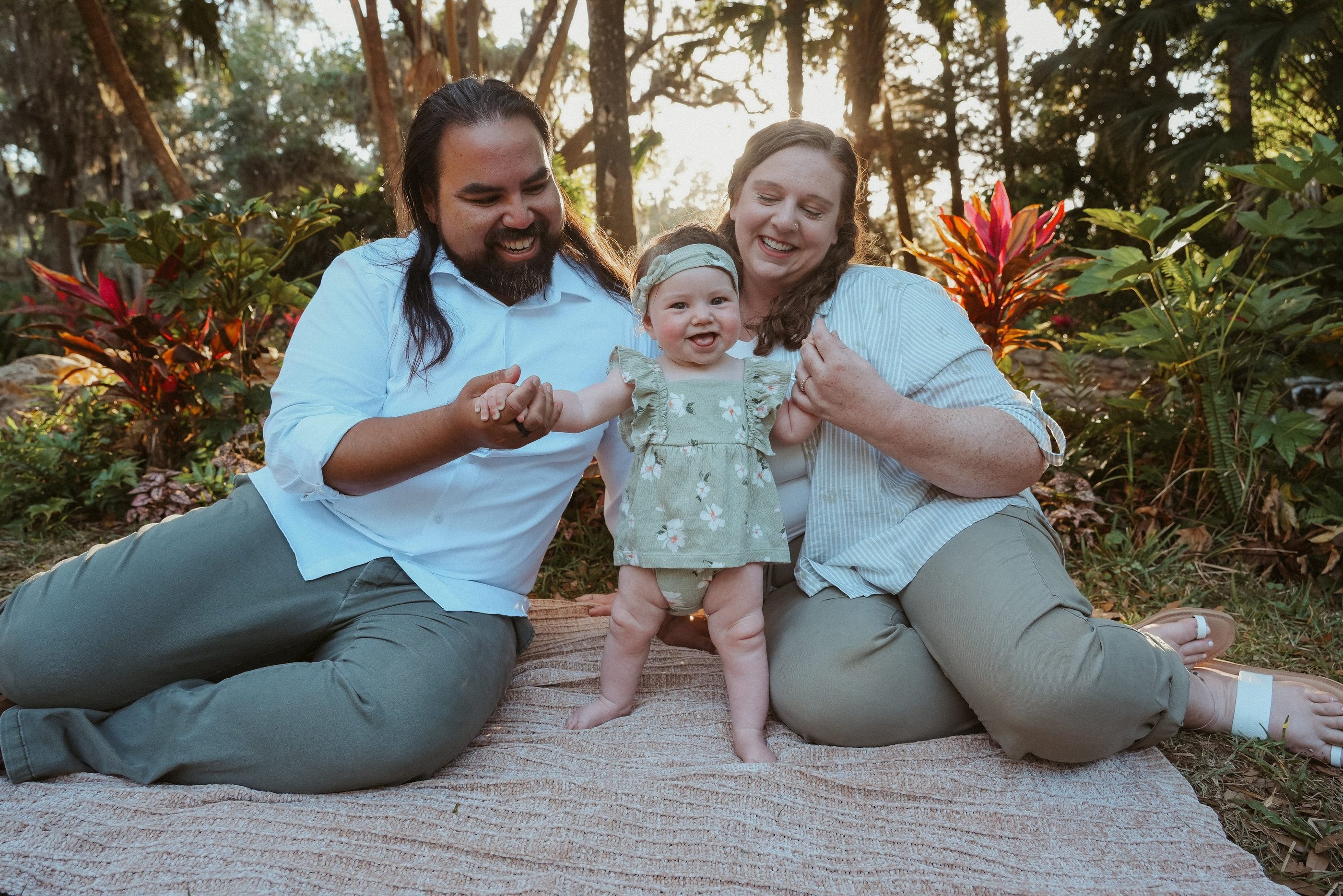 Family photo of Dr. Kevin Zelaya & Dr. Anna Abbott including their daughter with a sunset background