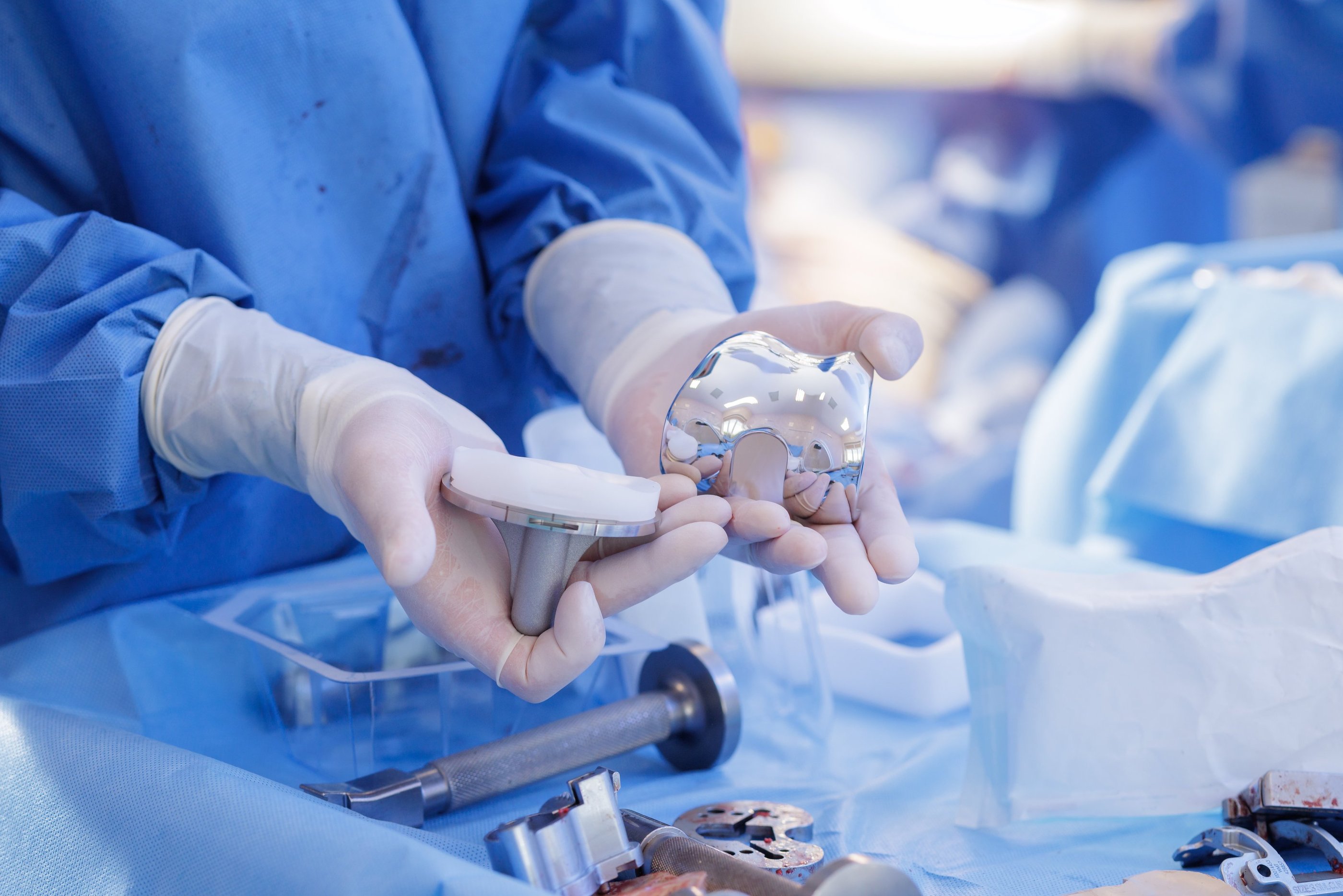 medical technical inspecting a set of orthopedic knee implants.