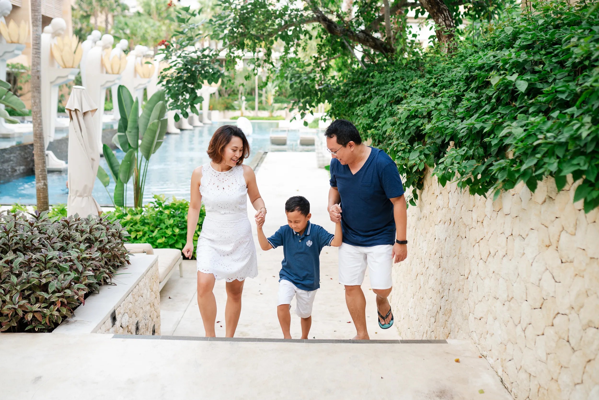 Family walking together on elegant resort stairs at The Mulia Nusa Dua Bali