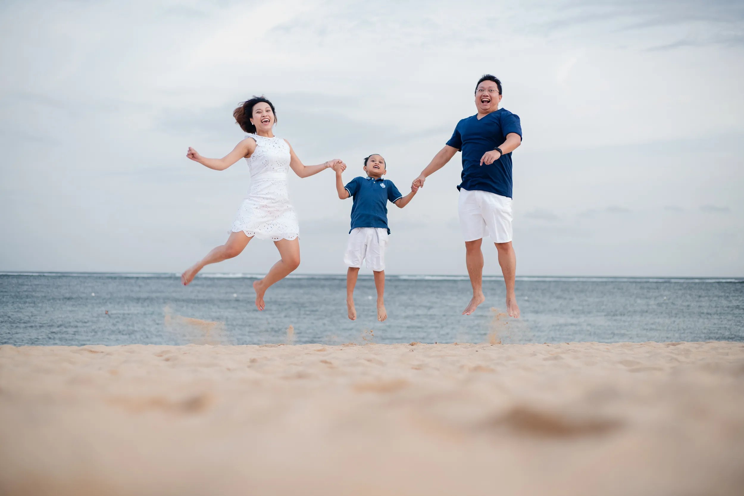 Family jumping together on the beach at The Mulia Nusa Dua Bali