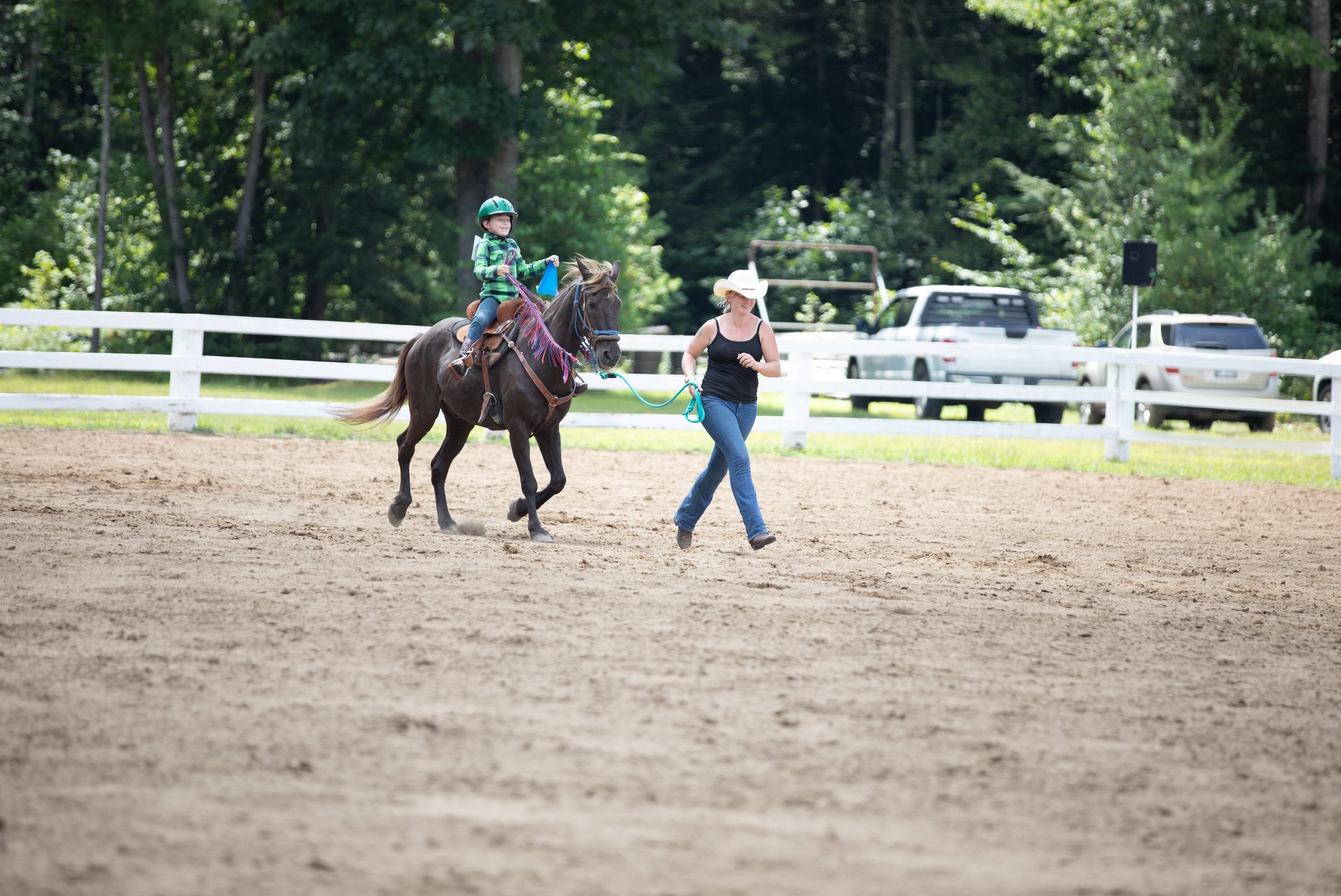 a junior riding a horse in a fenced in area