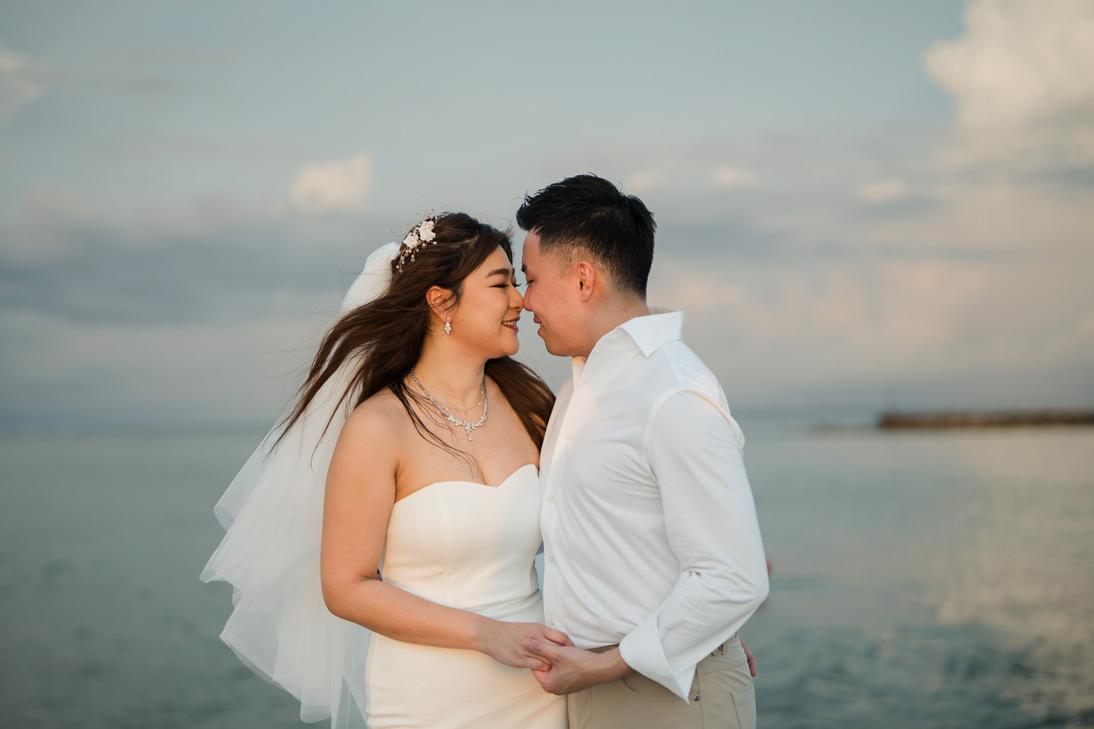 Couple embracing during a romantic beach prewedding photoshoot at Apurva Kempinski Bali