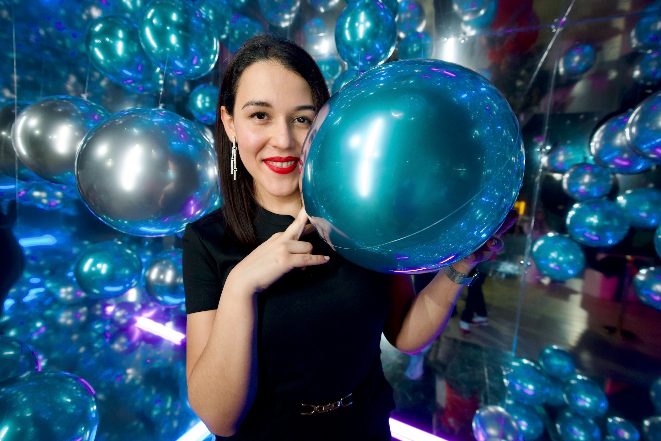 cabina espejada para eventos en Mallorca con invitada posando entre globos