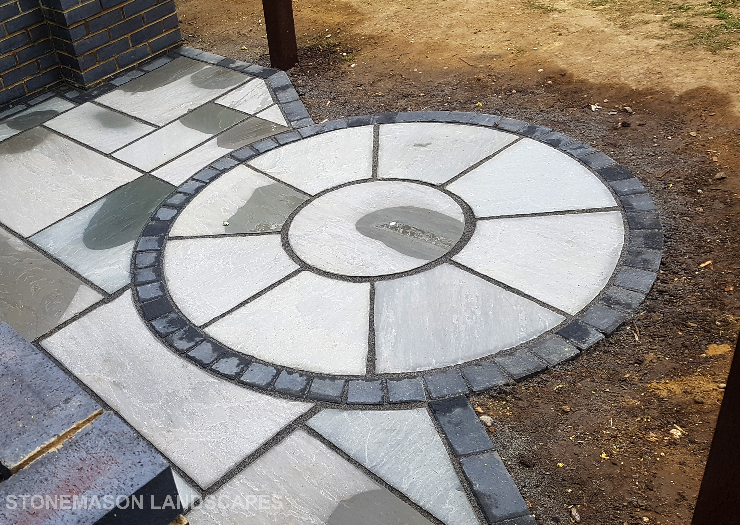 Grey sandstone circle paving slabs with charcoal edging