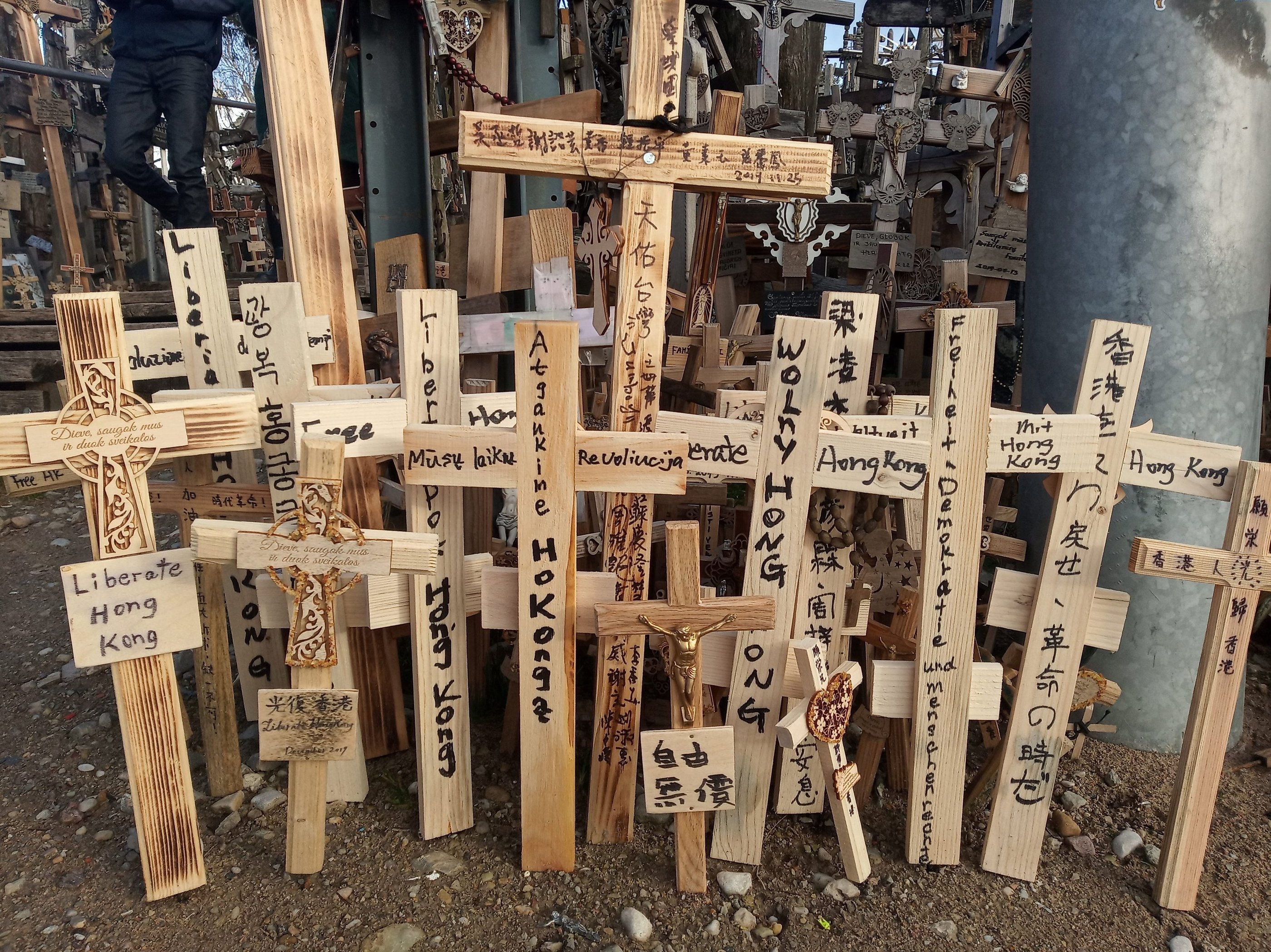 Handmade wooden crosses with Liberate Hong Kong messages at the Hill of Crosses pilgrimage site.