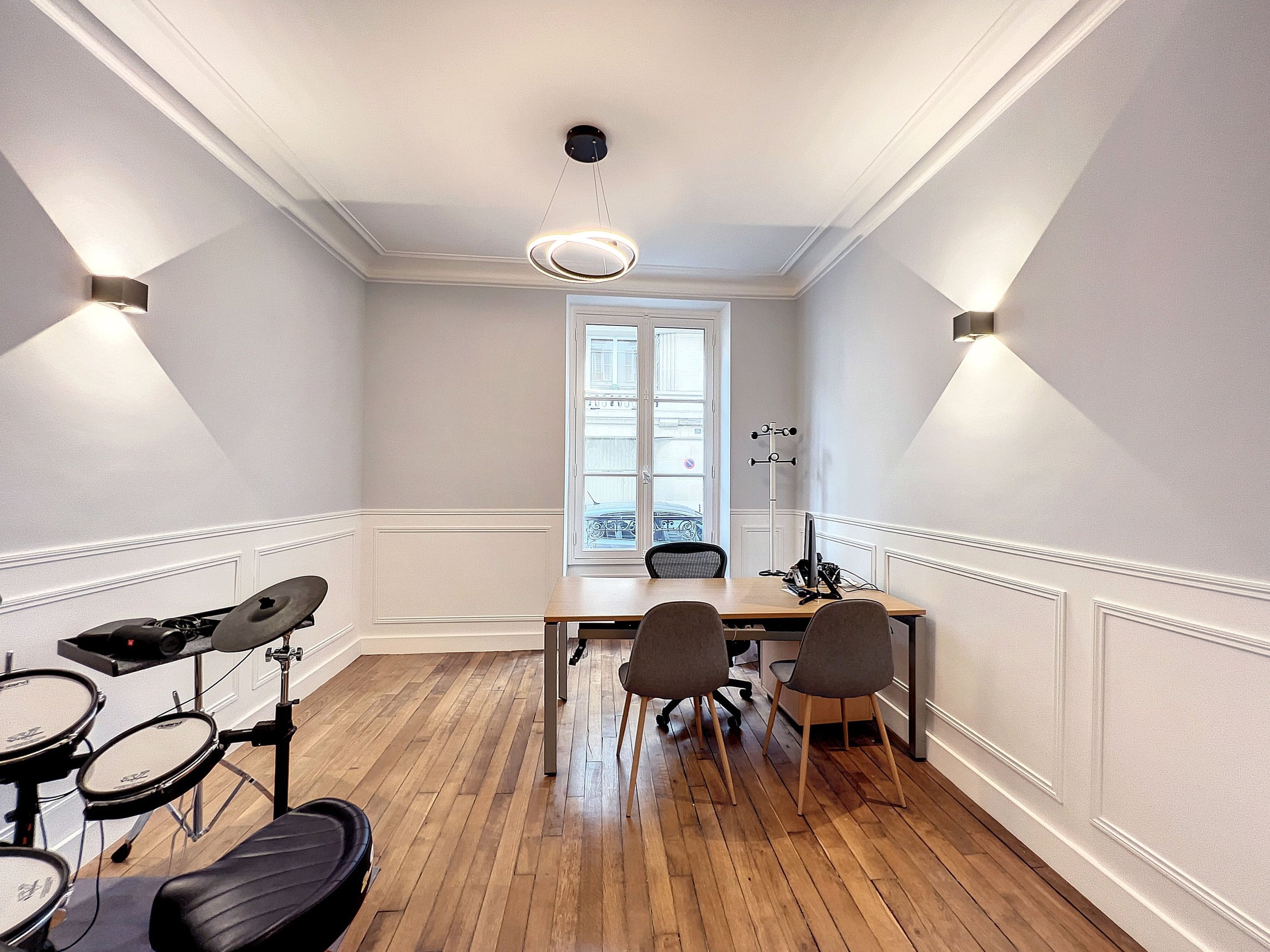 a room with a table and chairs and a drum set up