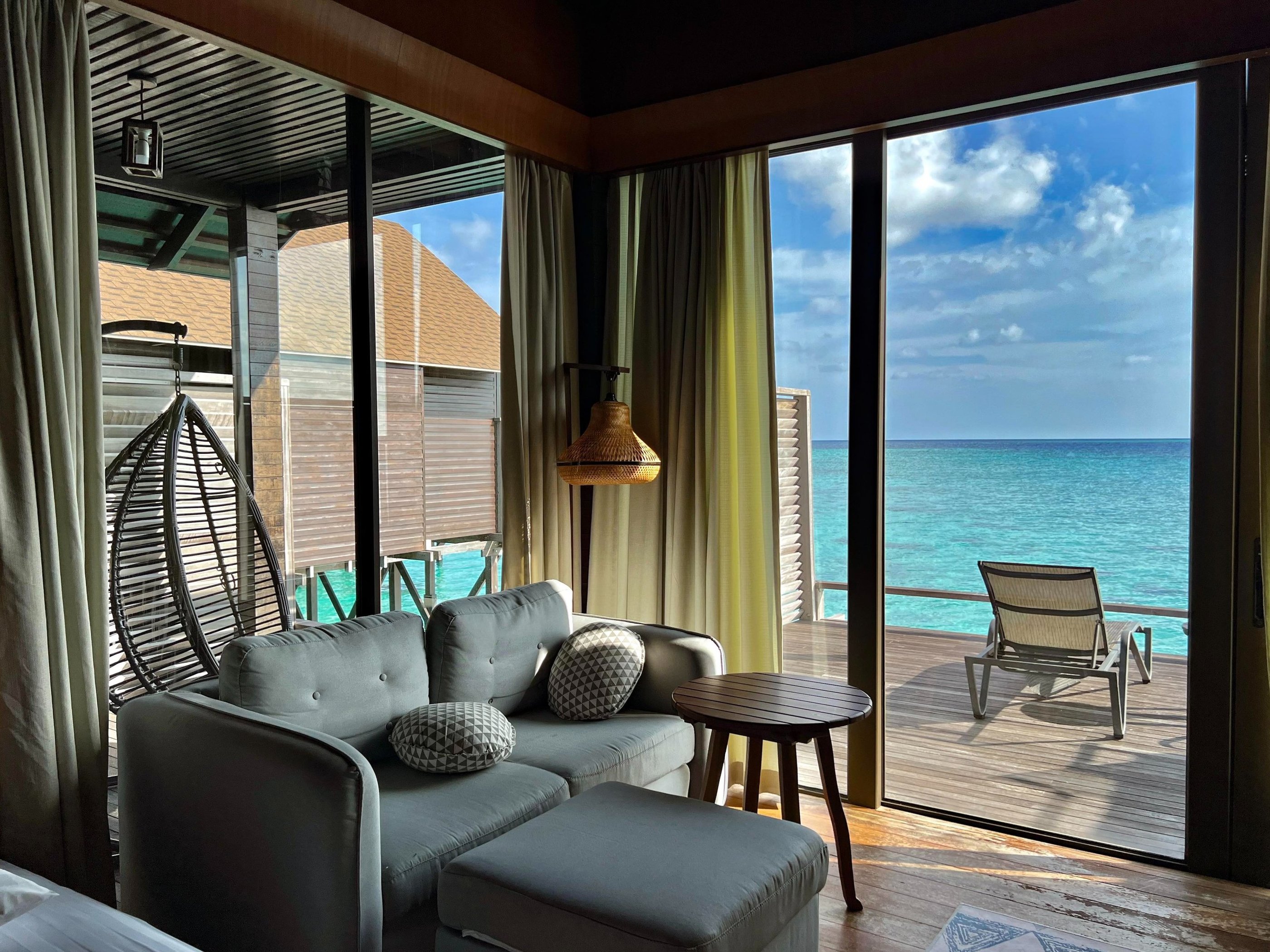 Sofa and living area inside a water chalet at Lankayan Island Resort.