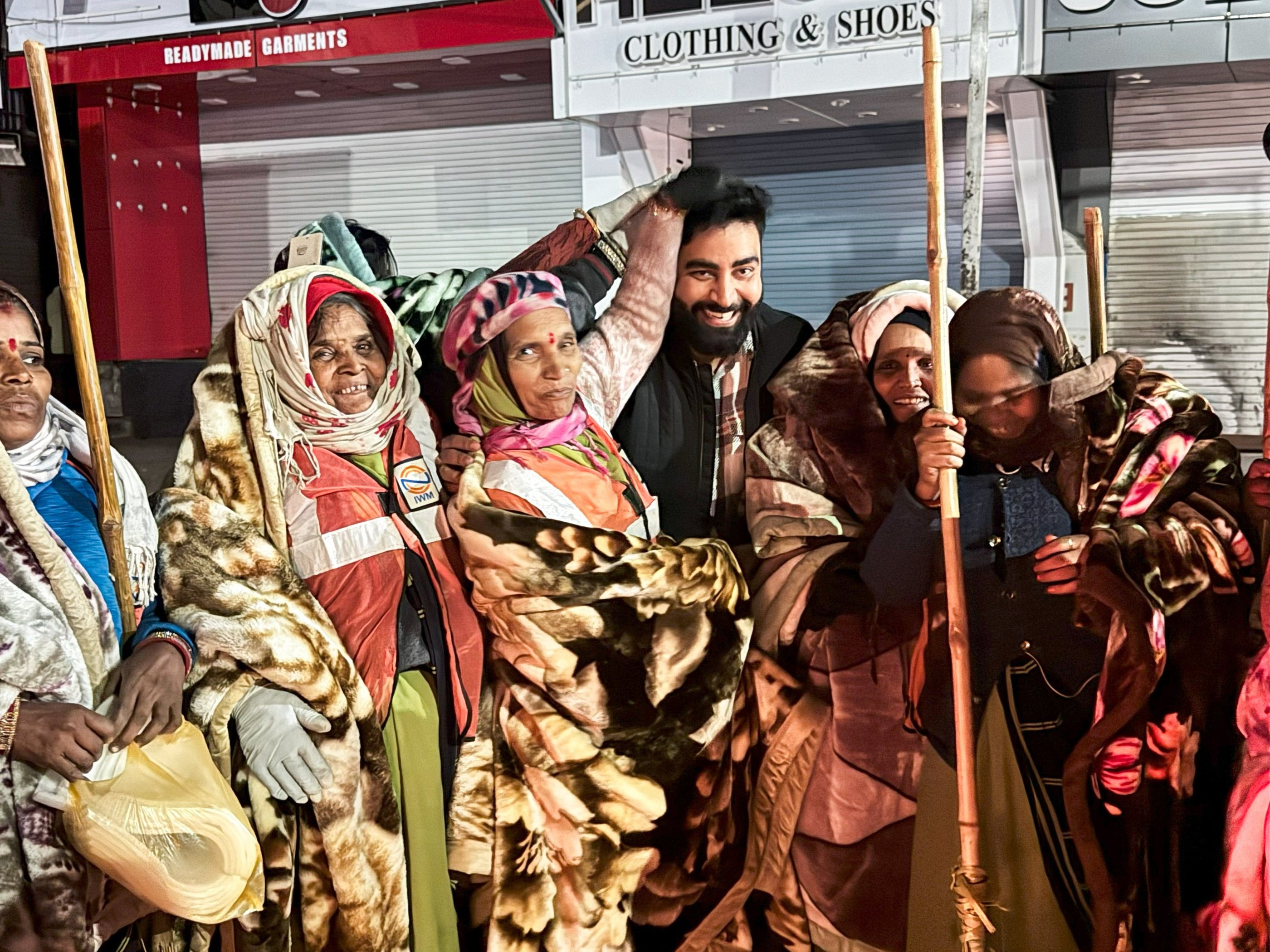 Community blanket drive with volunteers distributing warm blankets to people in need on a street