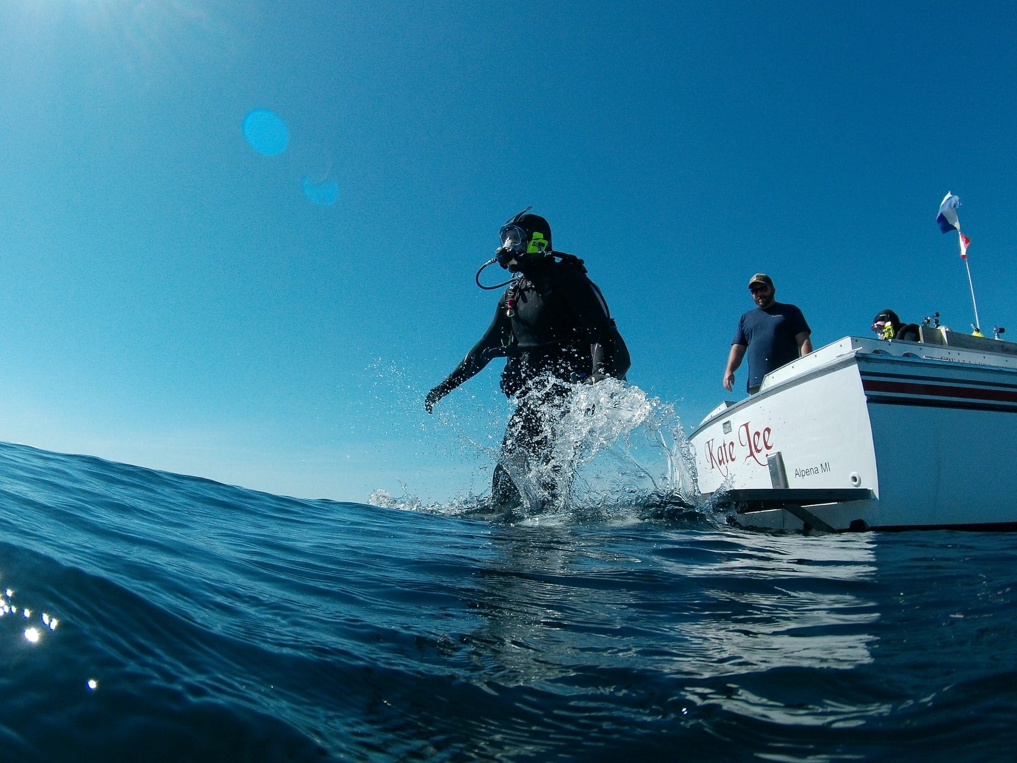 a scuba diver is jumping in the water