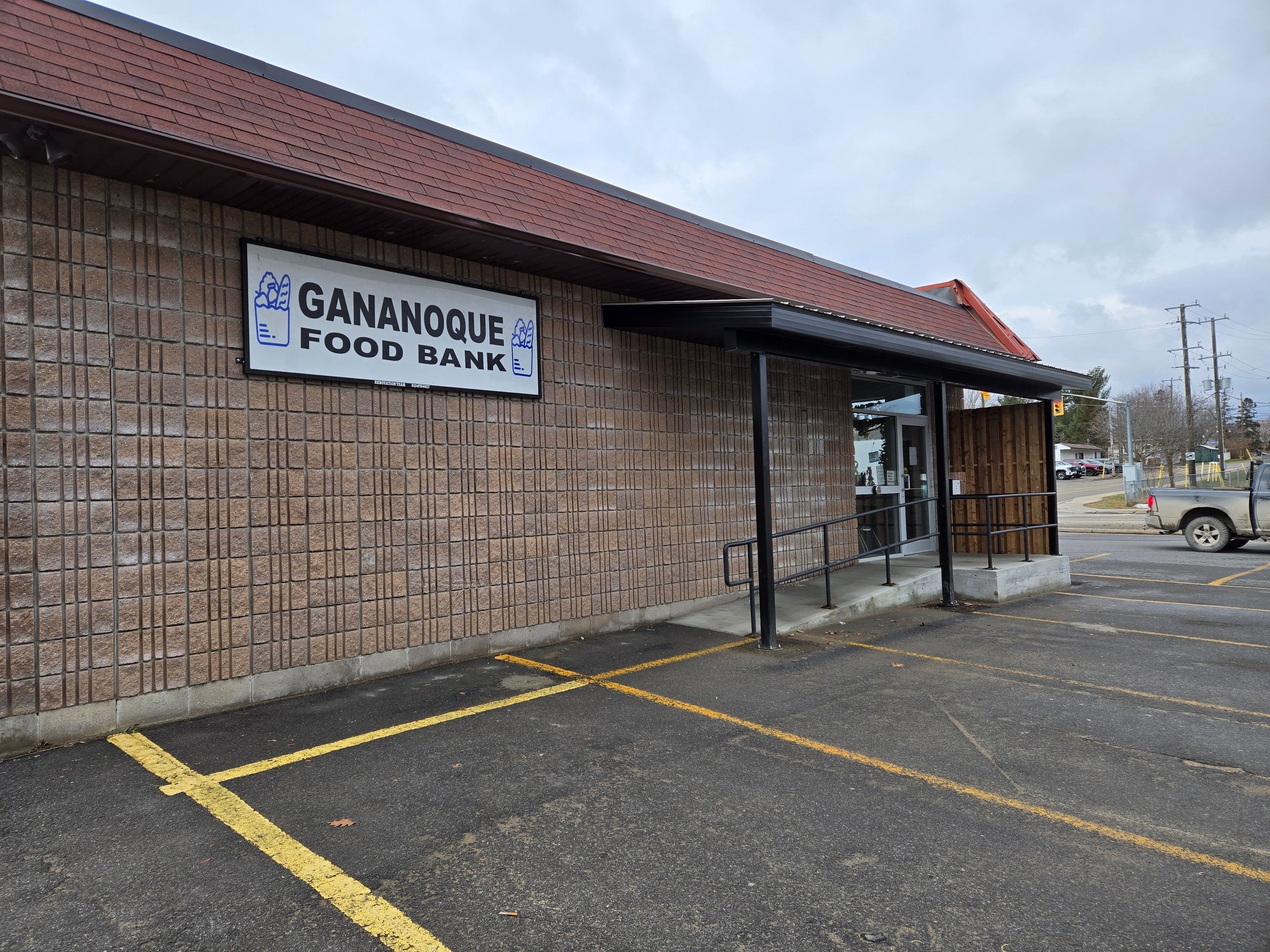 Exterior of the Gananoque Food Bank building with a brick facade and accessible ramp entry.