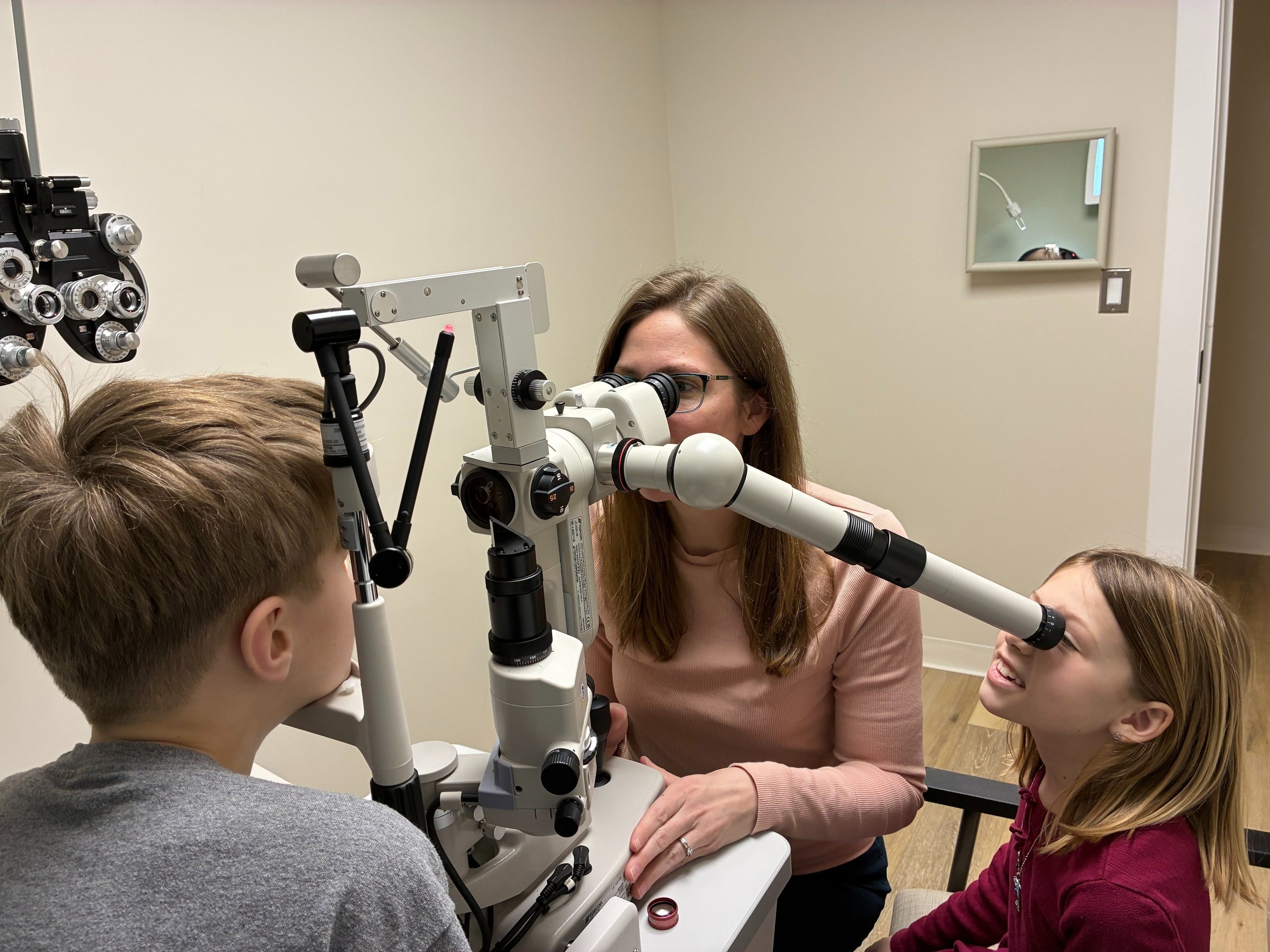 Doctor performing an eye exam on a patient for preventative and medical eye care in Southborough