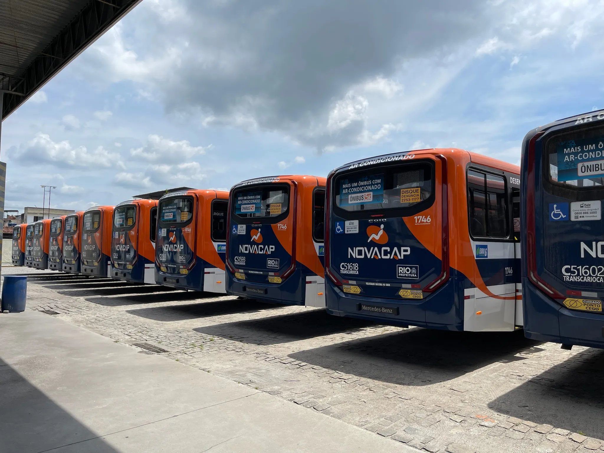 uma fileira de 16 ônibus 0km Caio Apache Vip V modelo 2024 vistos pela traseira