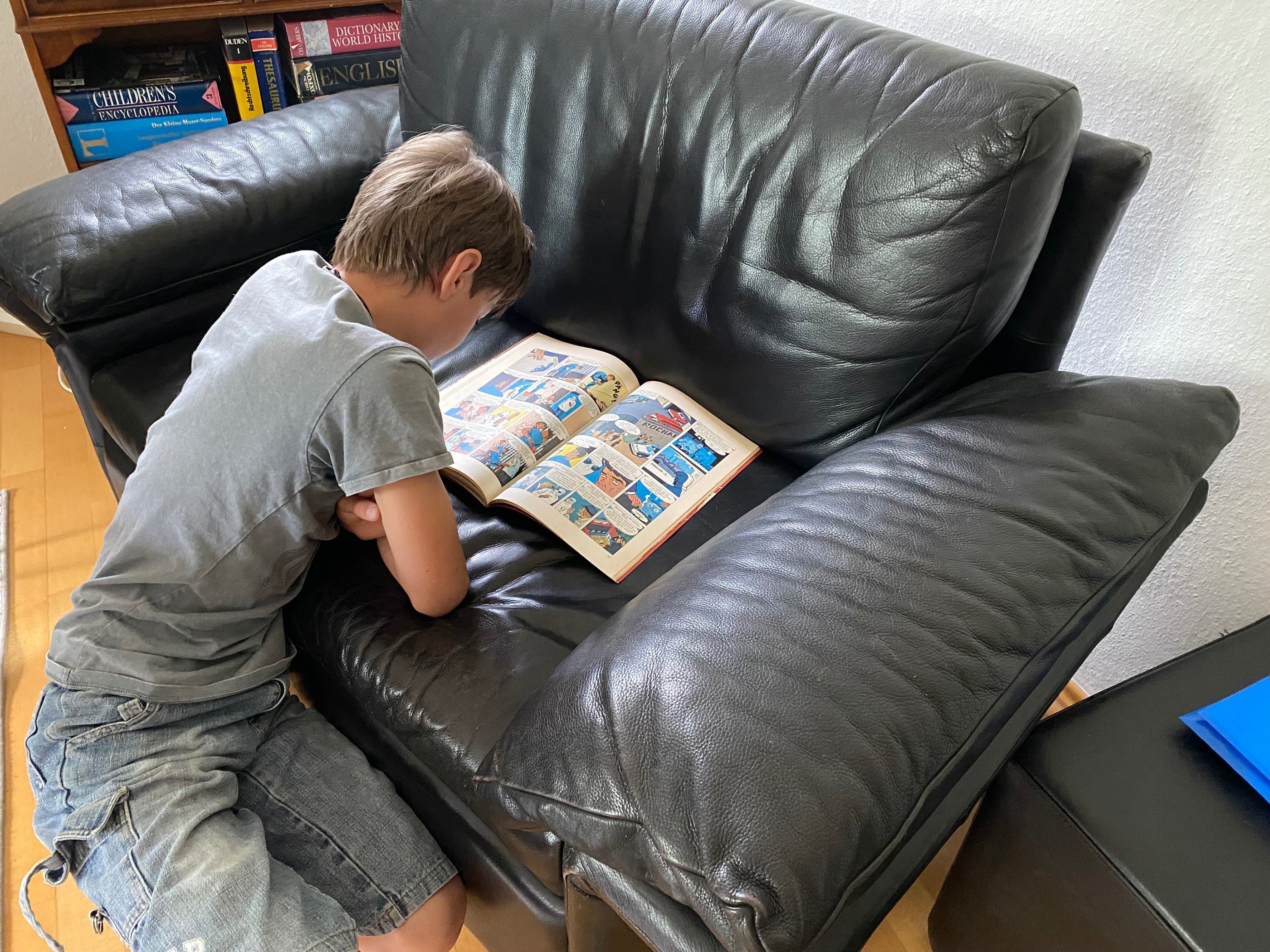 Junge liest fasziniert ein Comic-Heft