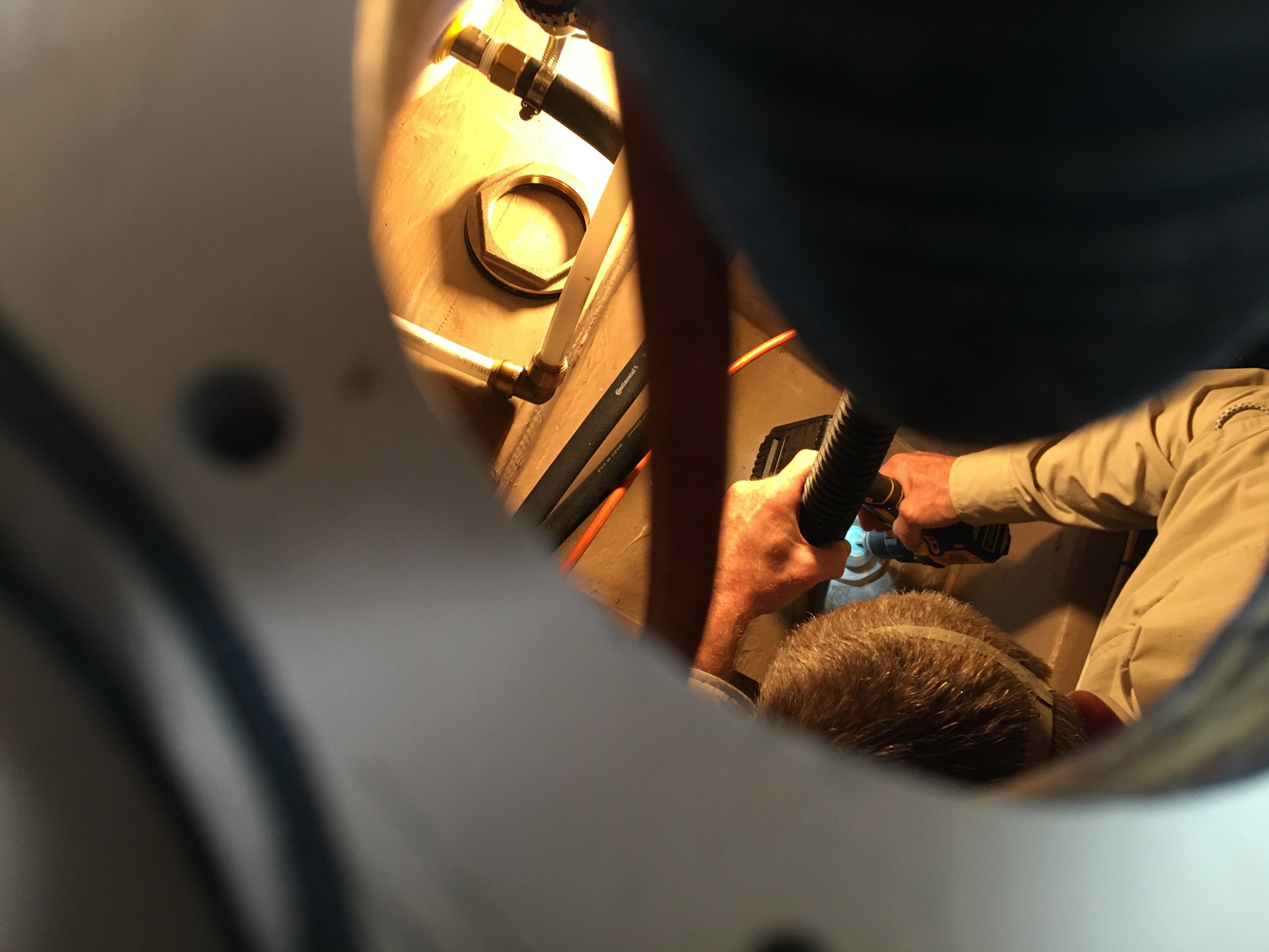 man working in compartment of boat