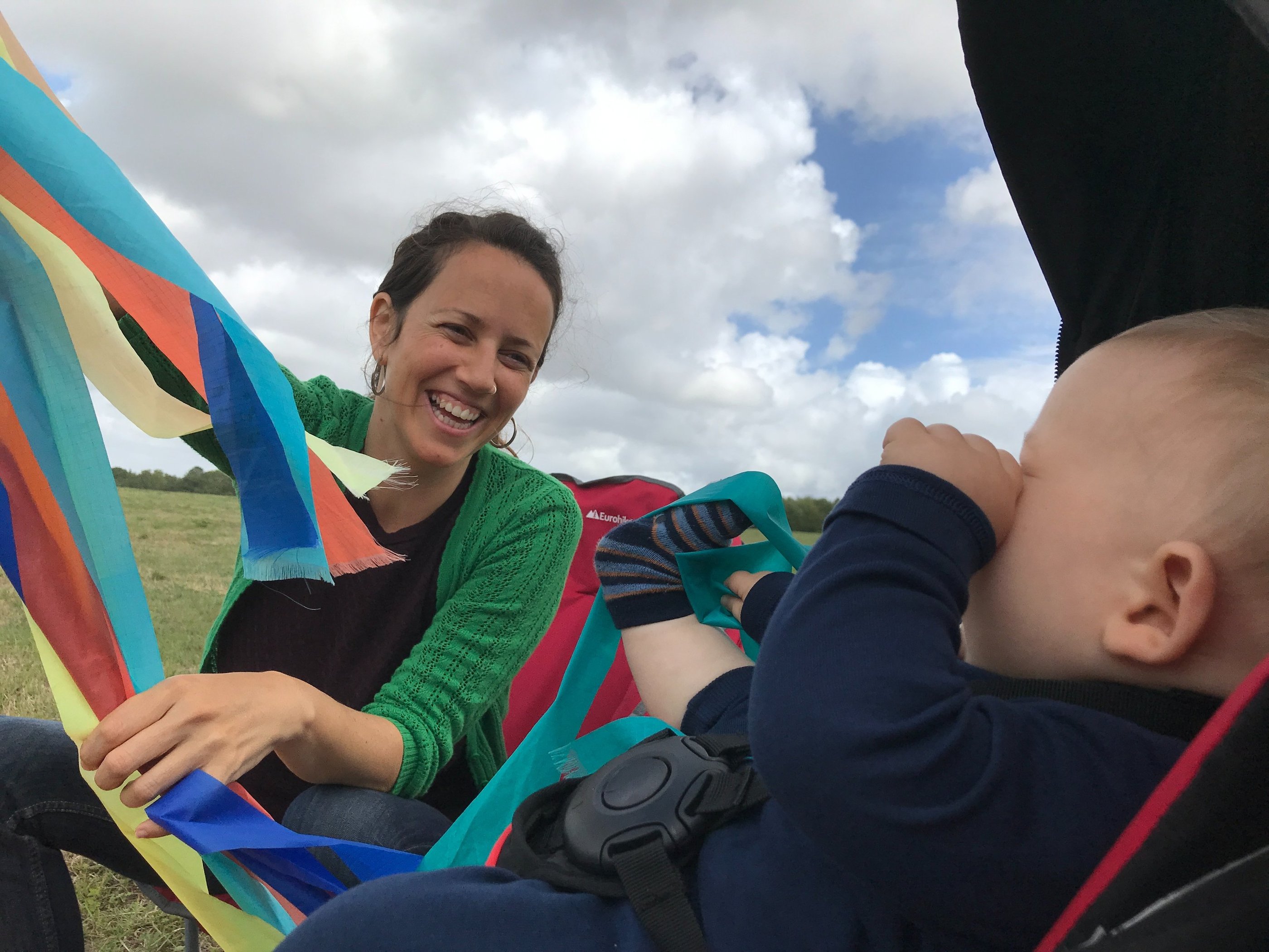 a woman sitting in a hammock with a baby