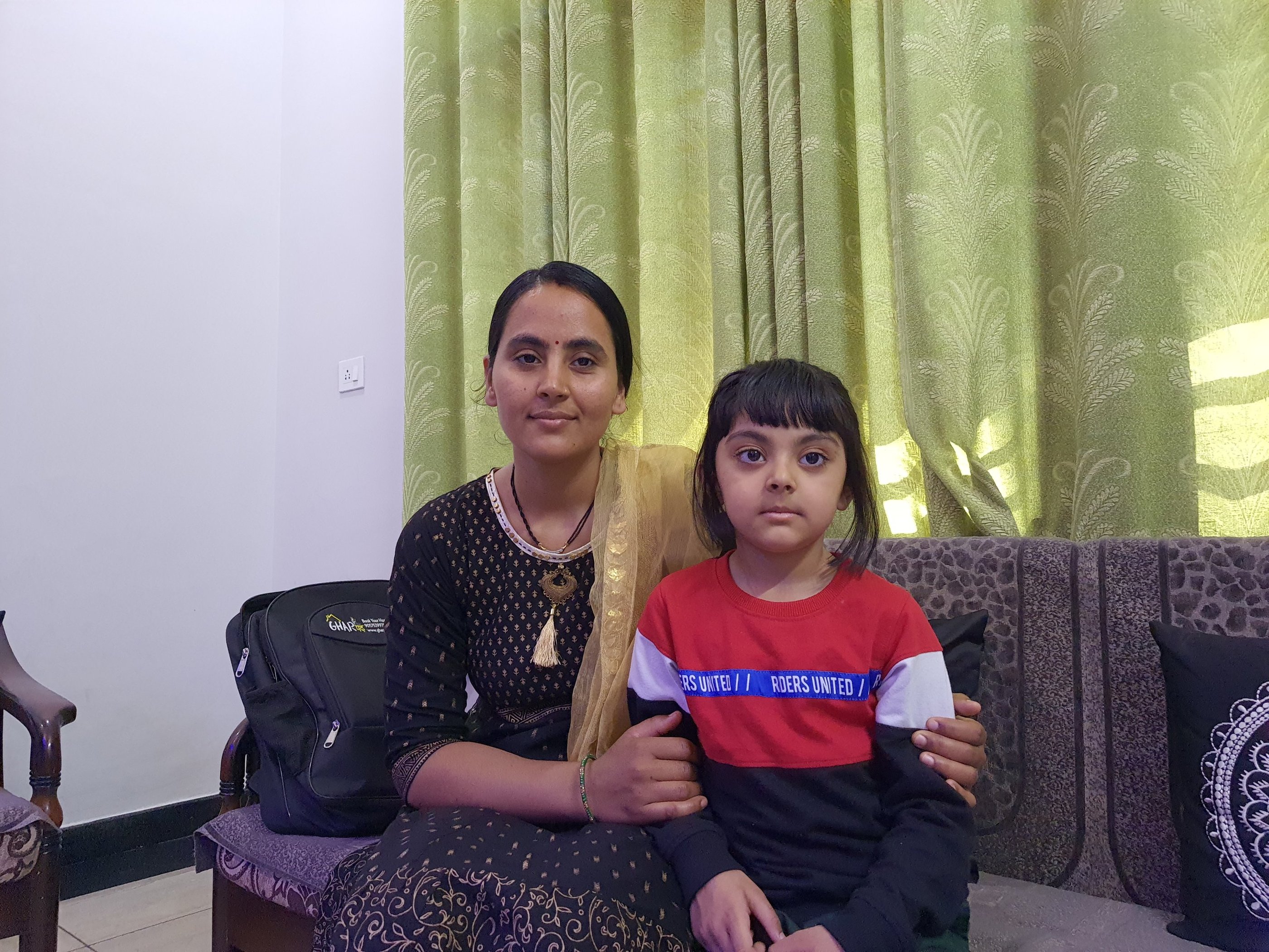 a woman sitting on a couch with her daughter