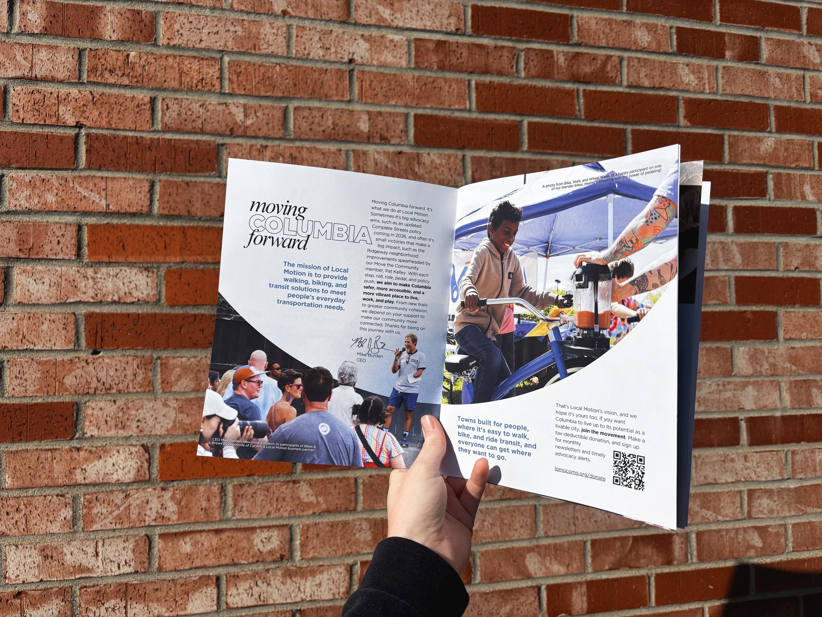 A hand holding open the 2025 Annual Report Booklet