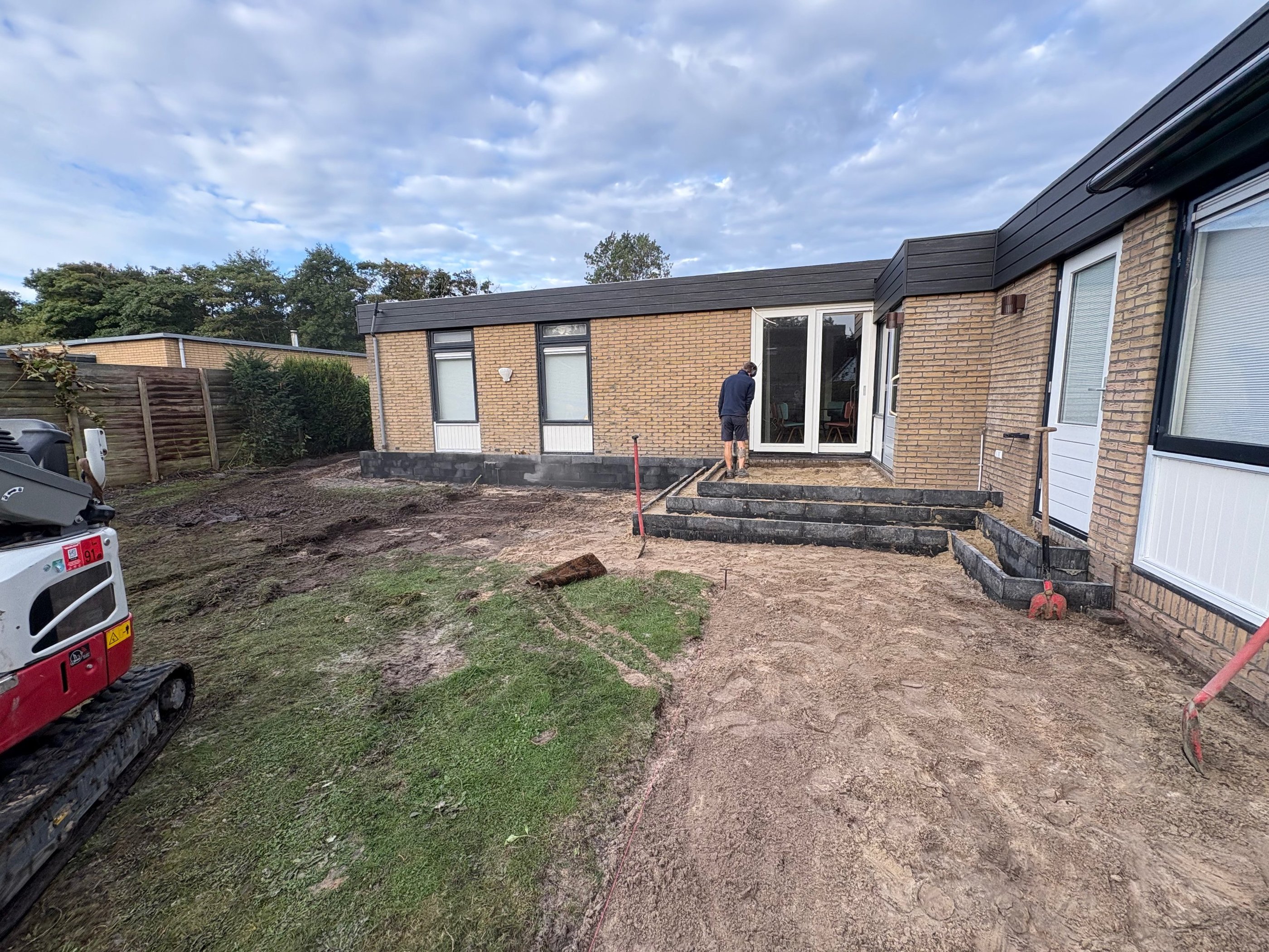 Betsema Bestrating bezig met grondwerk in een tuin.