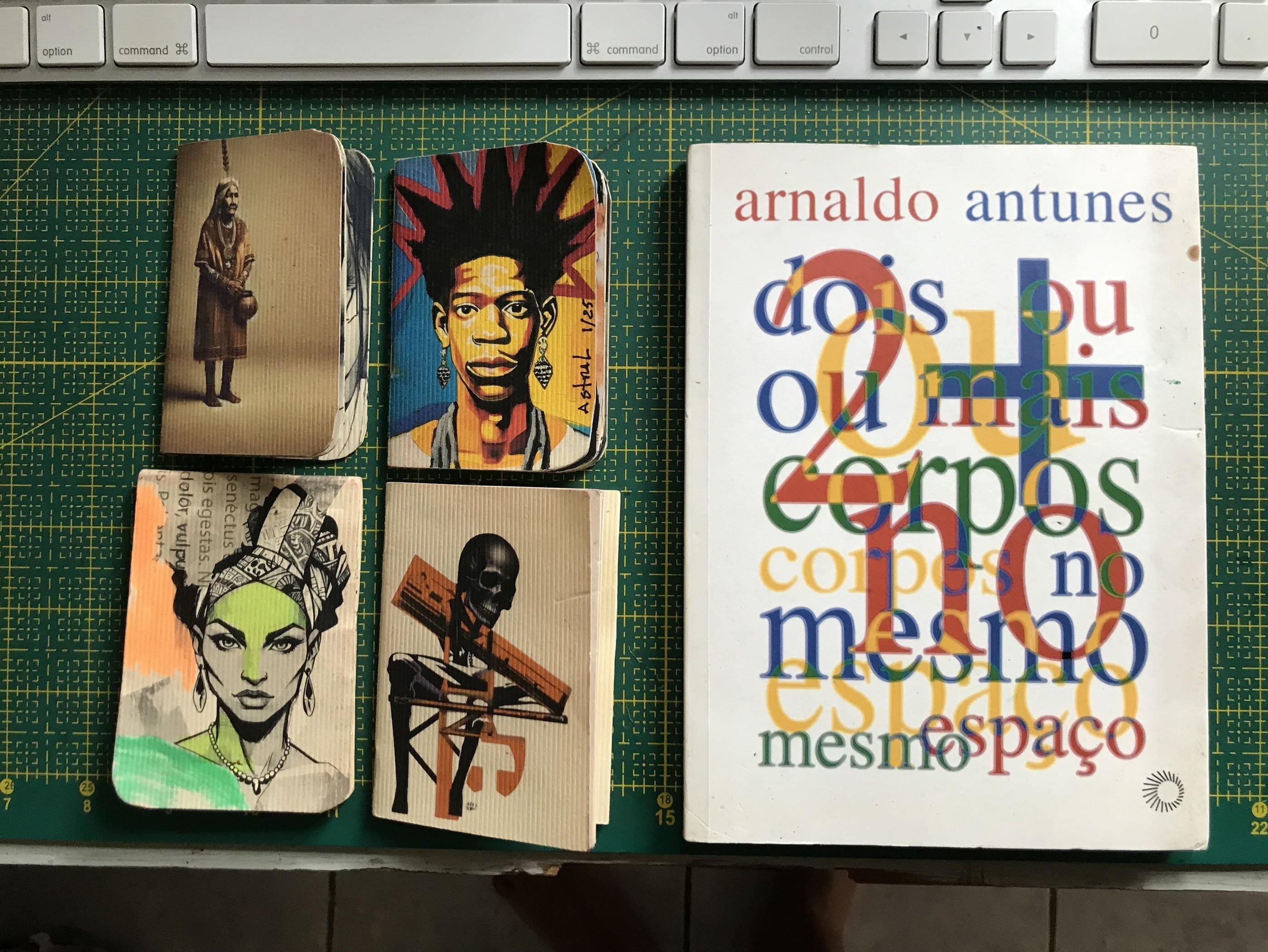 Caderno de artista com anotações e desenhos. Ao lado livro Arnaldo Antunes.
