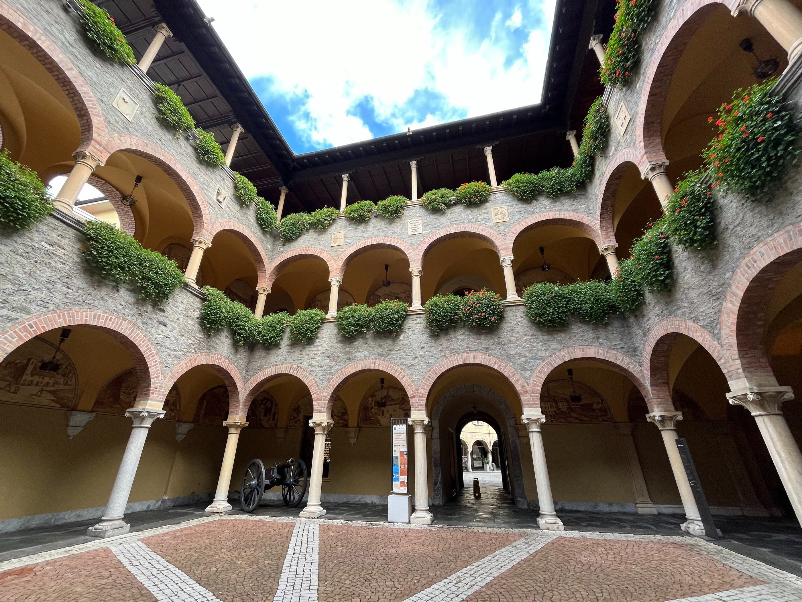 The internal courtyard of the Civic Palace in Bellinzona with lots of arches and flowers