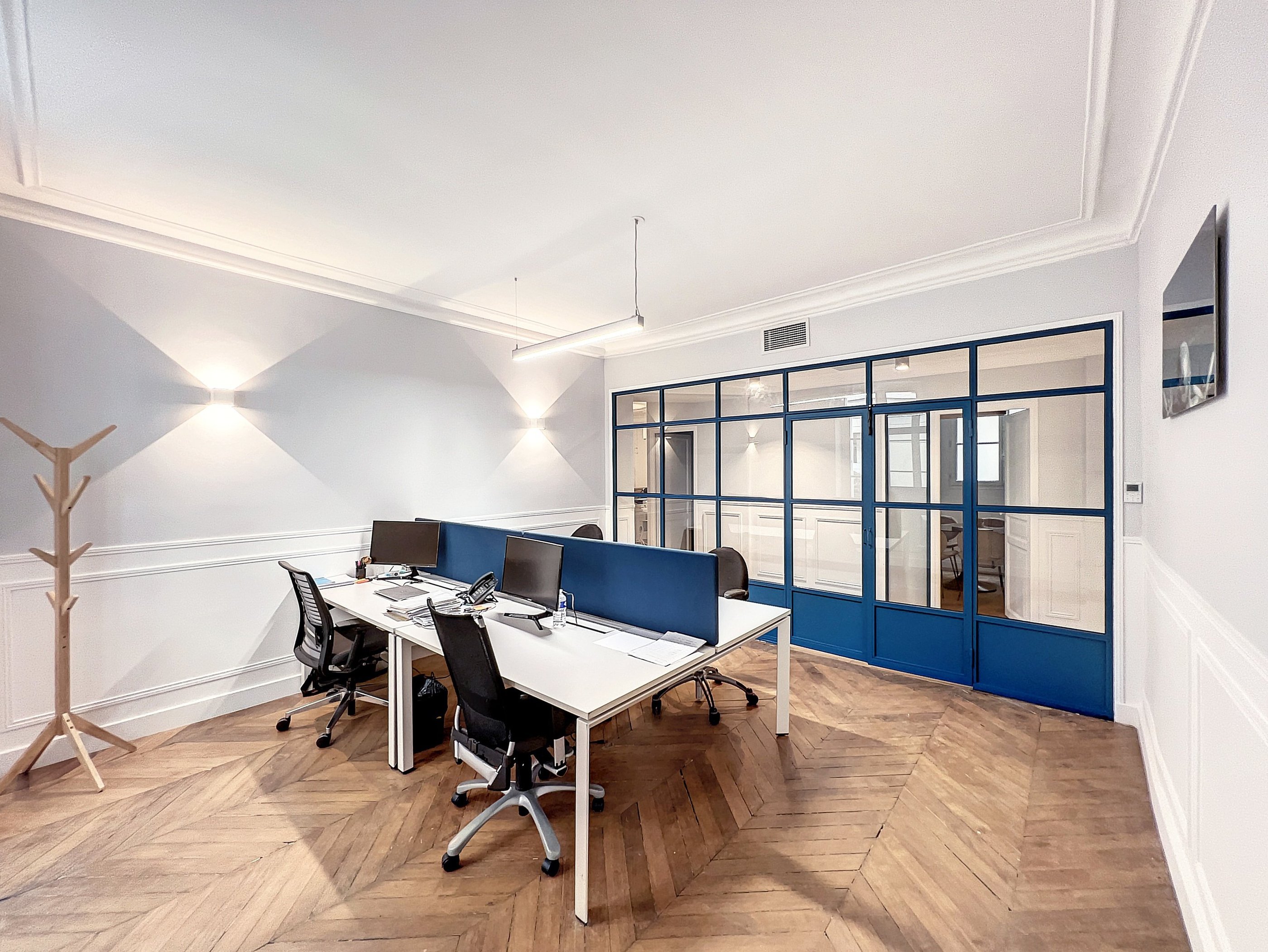 a desk with two computers and a monitor on a desk