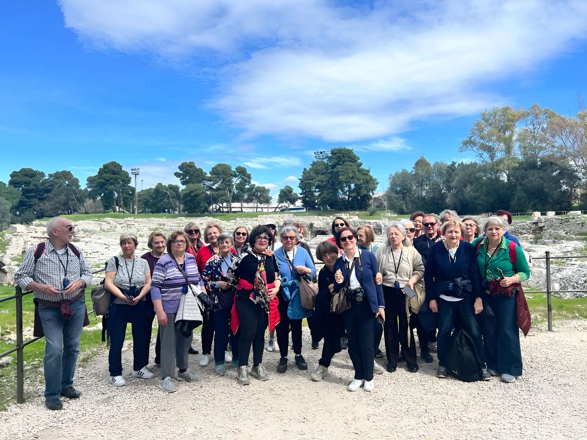 a group of people standing in front of a fence