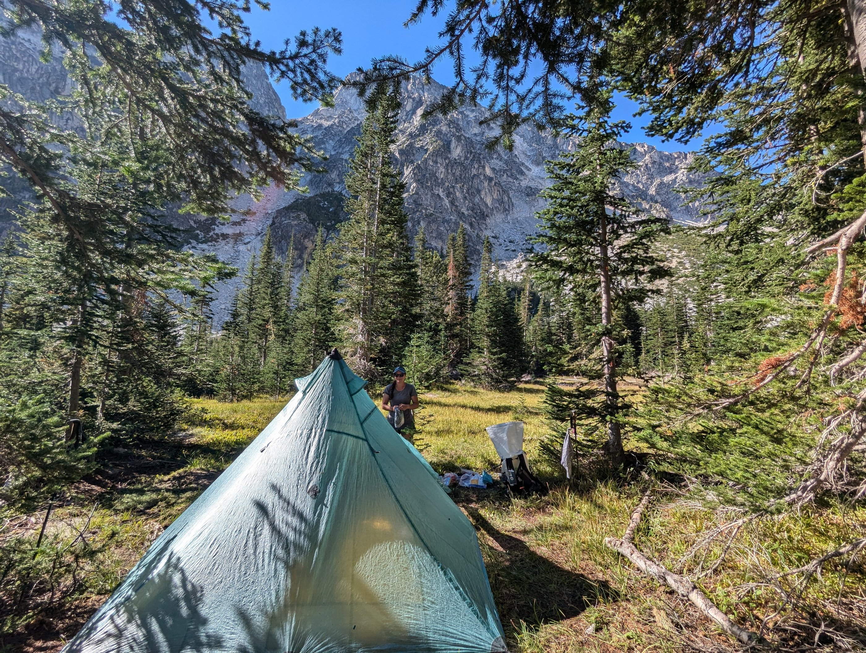 A hiker at a mountain campsite with a Hyperlite Ultamid 2 tent in the Alpine Lake Wilderness.