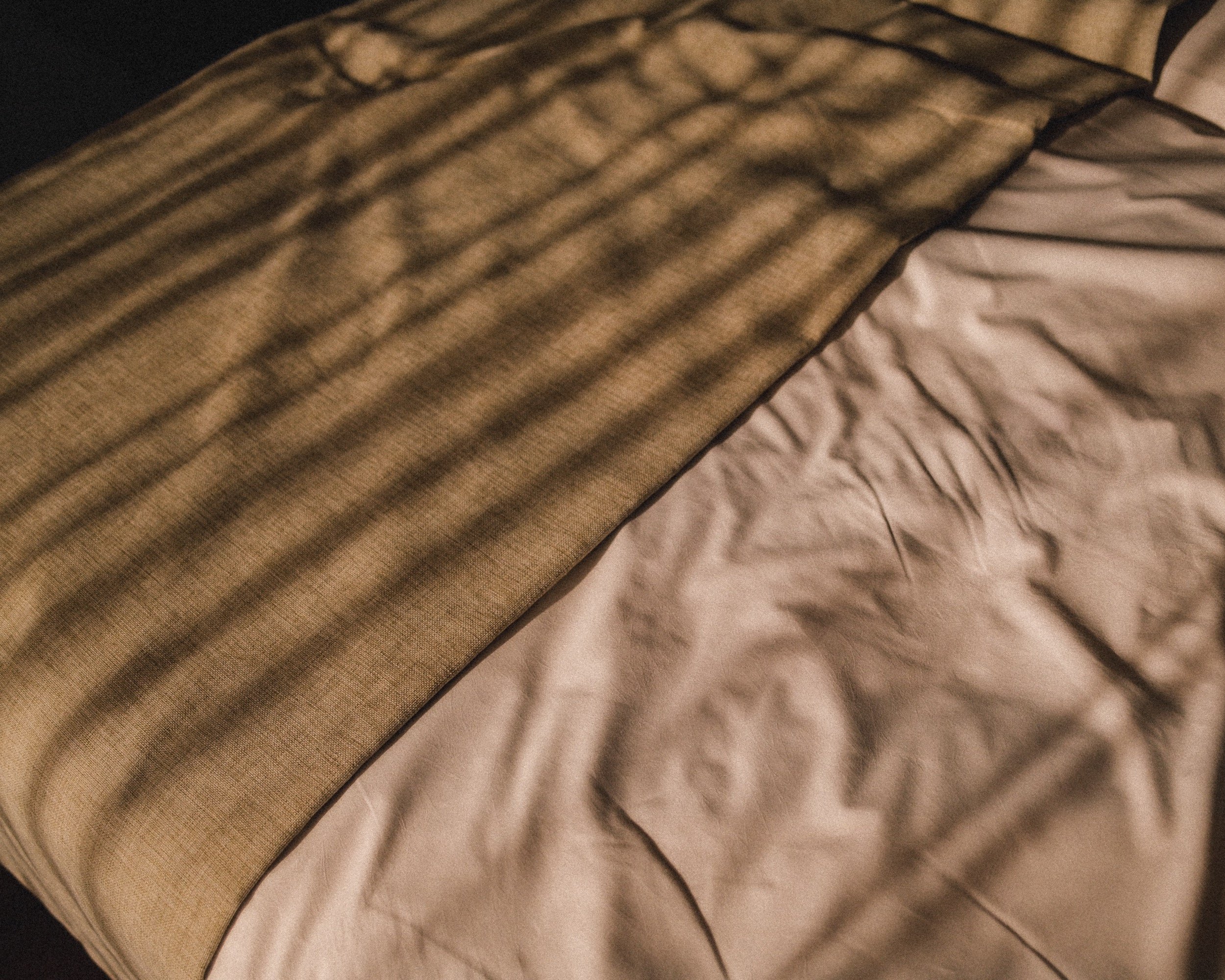 Bettdecke mit Licht und Schatten – Detailaufnahme Hotelzimmer