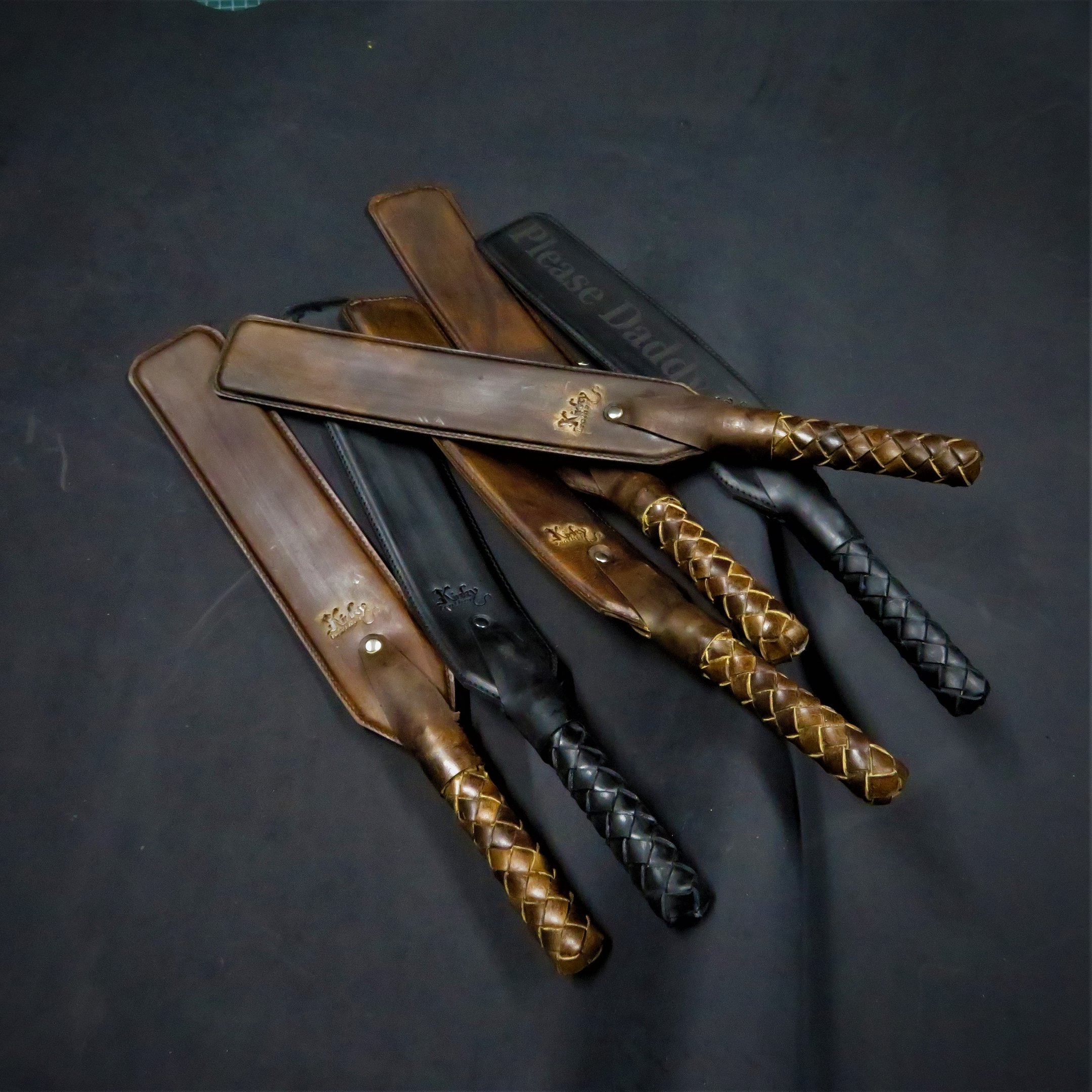 a set of leather paddles with braided handles
