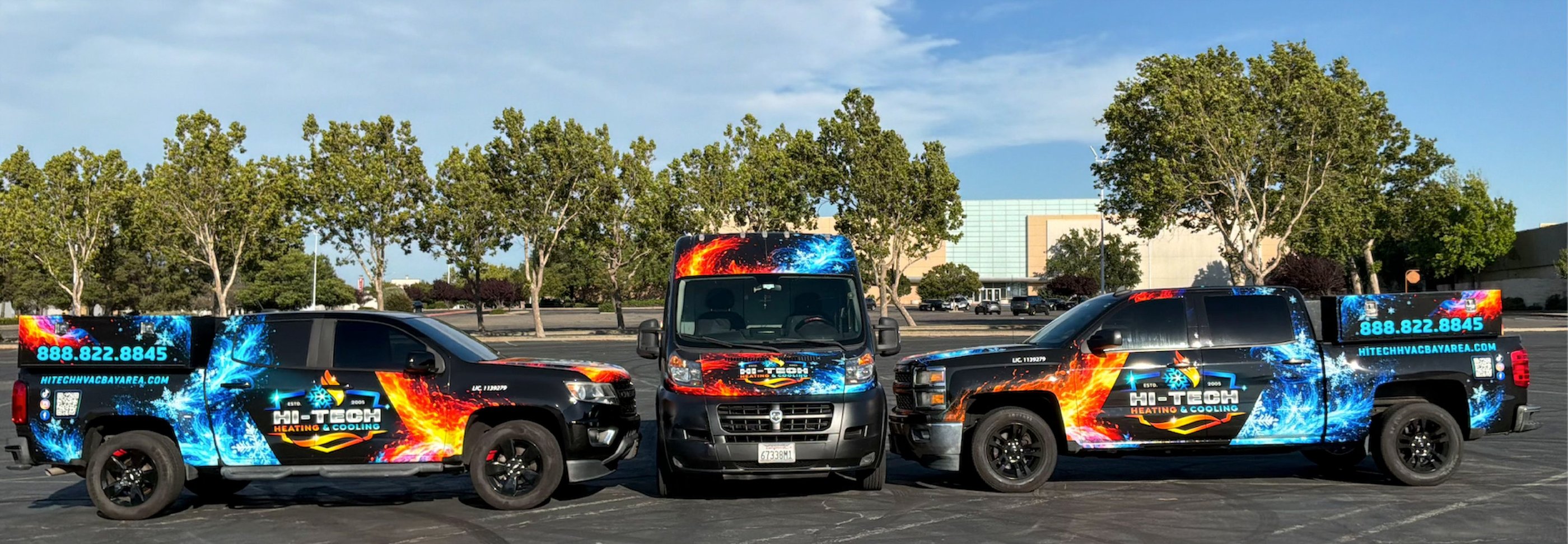 A fleet of Hi-Tech Heating and Cooling HVAC service trucks and vans with custom fire and ice wraps parked in a lot.
