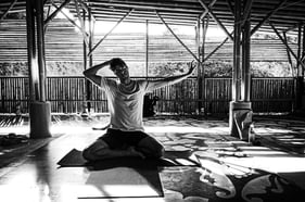 A man practices gentle neck stretches during yoga practice.