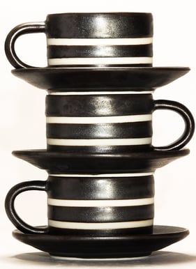 a stack of three cups with a cup of coffee
