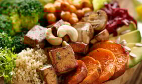 a bowl of vegan food with vegetables and tofu