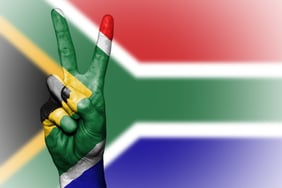 a person's hand holding up a peace sign