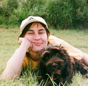 an image of the mediator laying casually on the grass with her dog